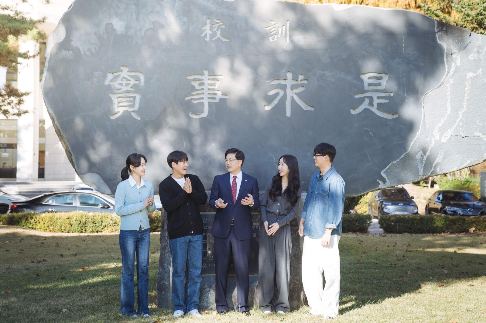 강원대 정재연 총장과 학생들이 강원대 교훈 앞에서 담소를 나누고 있다. 강원대 제공