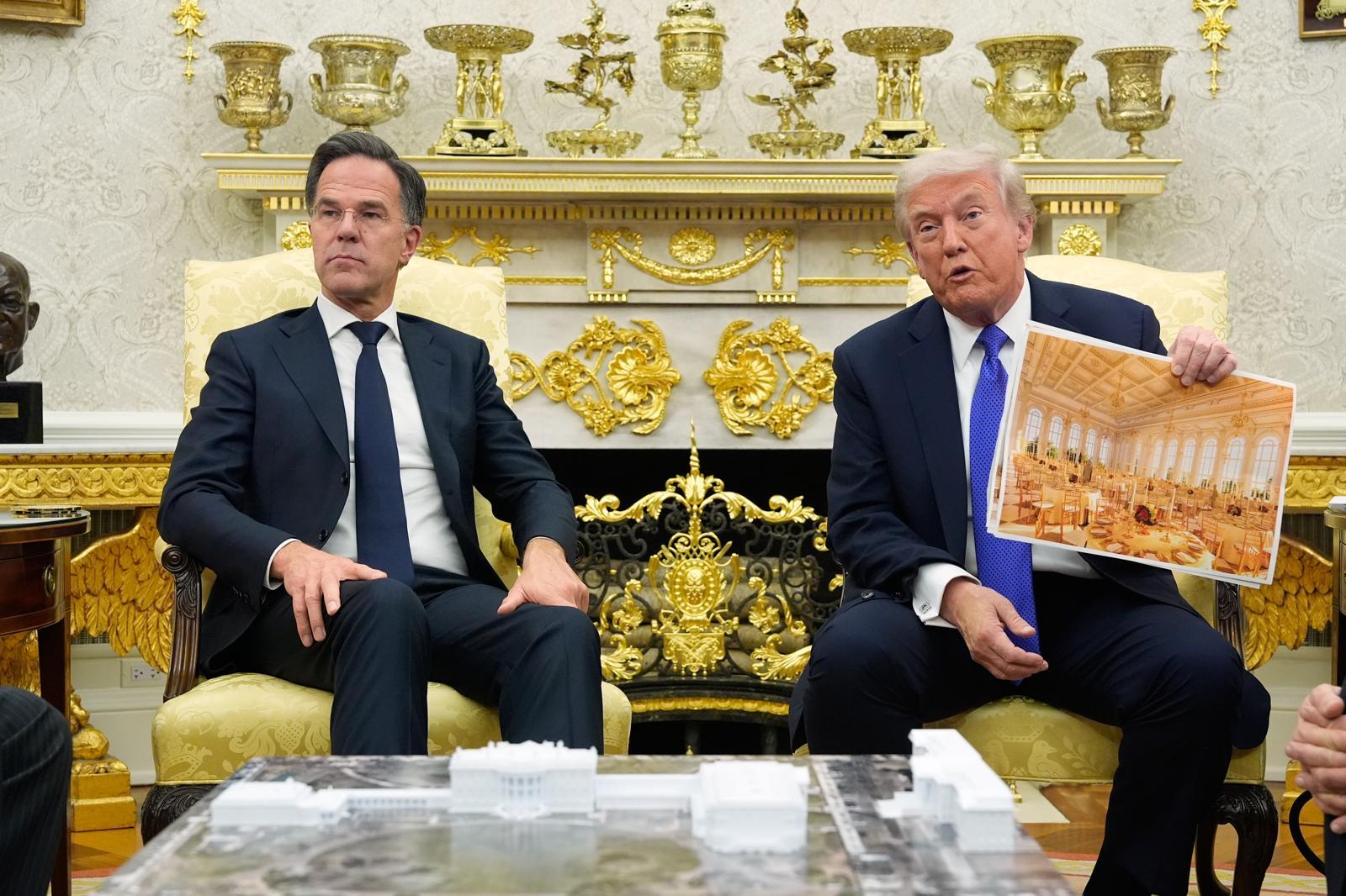 트럼프 대통령이 지난 10월 마크 뤼터 북대서양조약기구(나토) 사무총장과의 백악관 정상회담 도중 백악관 연회장 조감도를 꺼내들어 설명하고 있다. 워싱턴=AP 뉴시스