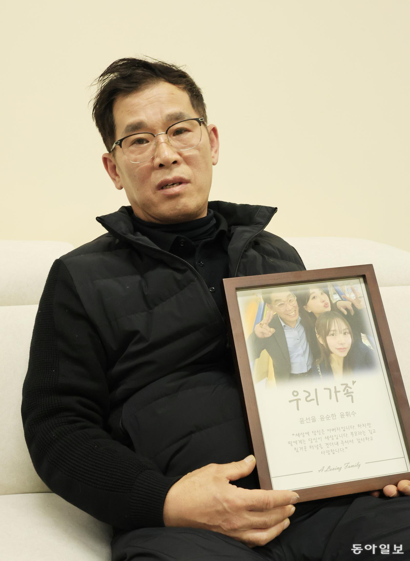 무안공항 제주항공 참사로 숨진 둘째 딸 휘수 씨와 함께 찍은 사진을 들고 있는 윤순한 씨. 액자에는 “세상에 당신은 아버지입니다. 하지만 딸에게는 당신이 세상입니다. 부모라는 깊고 힘겨운 터널을 견뎌내 주셔서 감사하고 사랑합니다”라고 적혀 있다. 광주=박영철 기자 skyblue@donga.com