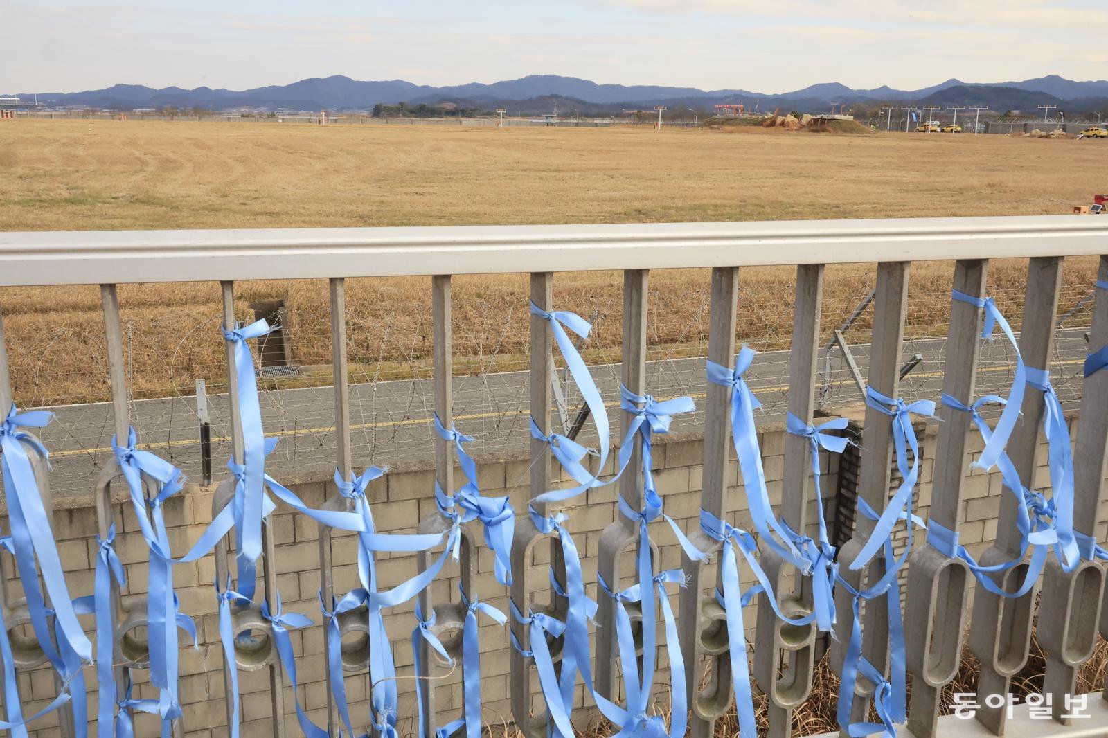 제주항공 참사 1주기를 하루 앞둔 전남 무안공항 사고 현장이 보이는 활주로 전망대에 추모 현수막과 파란 리본이 걸려 있다. 무안=박영철 기자 skyblue@donga.com