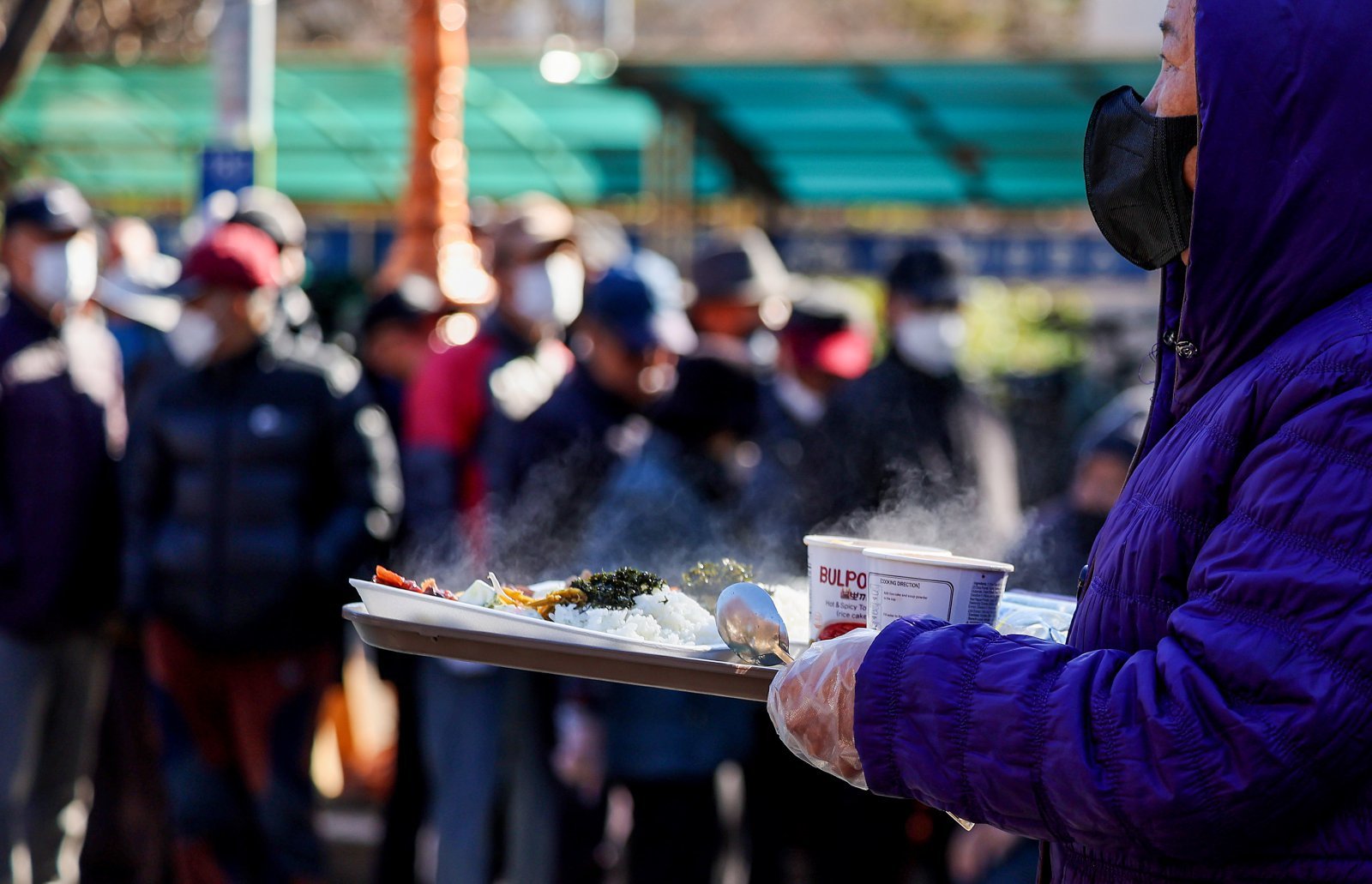 쌀쌀한 날씨를 보인 9일 대구 달서구 두류공원 사랑해밥차 무료 급식소에서 한 어르신이 배식 받은 점심을 들고 이동하고 있다. 2025.12.09. [대구=뉴시스]