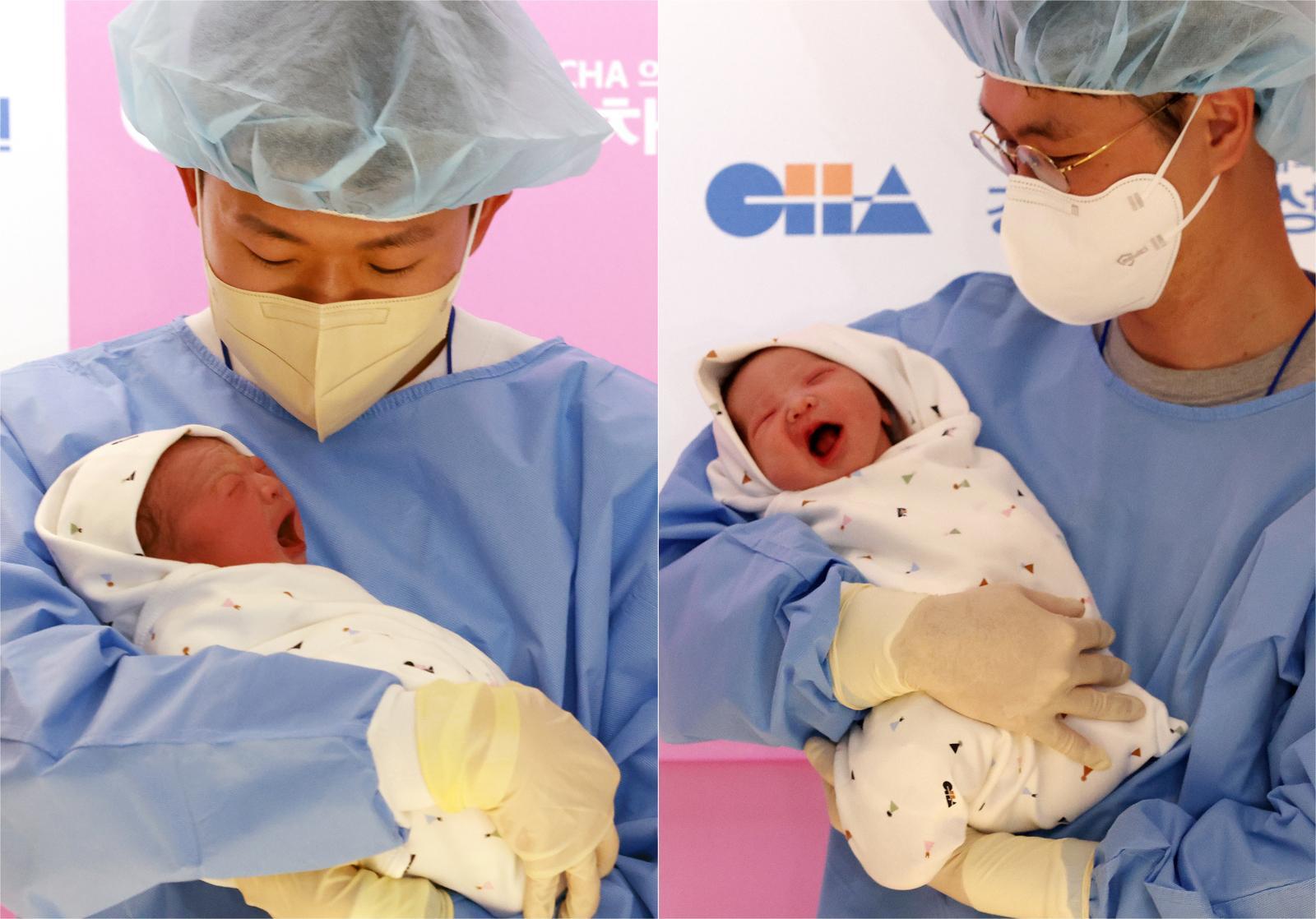 1일 0시 0분 서울 강남구 강남차여성병원에서 올해 첫 신생아 2명이 동시에 태어났다. 마스크를 착용하고 위생장갑을 낀 아빠들이 아이들을 안은 채 바라보고 있다. 뉴시스