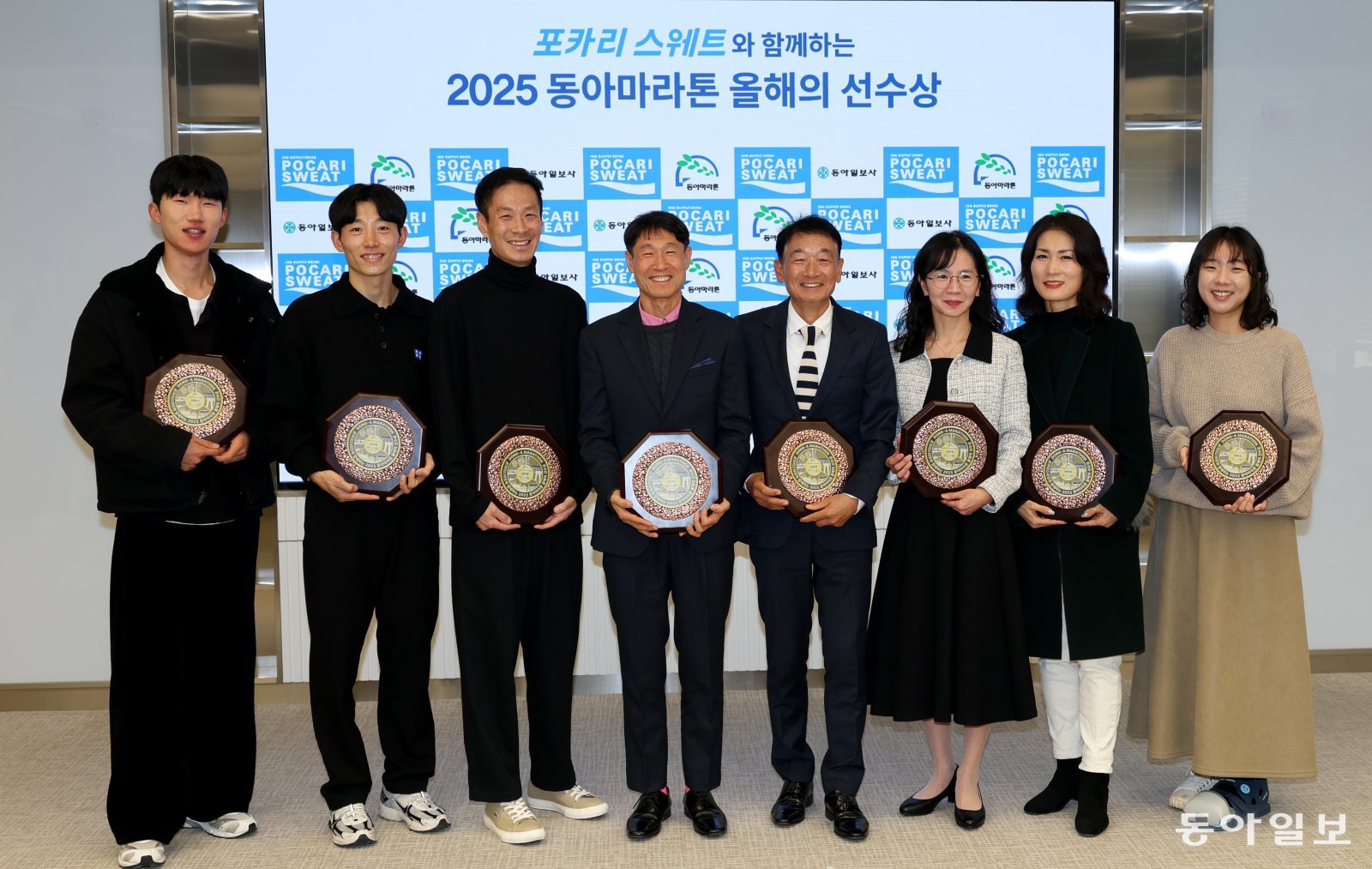 정명교 교사(오른쪽)가 2025 동아마라톤 올해의 선수상 수상자들과 함께 포즈를 취했다.  지난해 마지막 풀코스 도전에 왼발을 다친 정 교사는 깁스하고 참석했다. 변영욱 기자 cut@donga.com