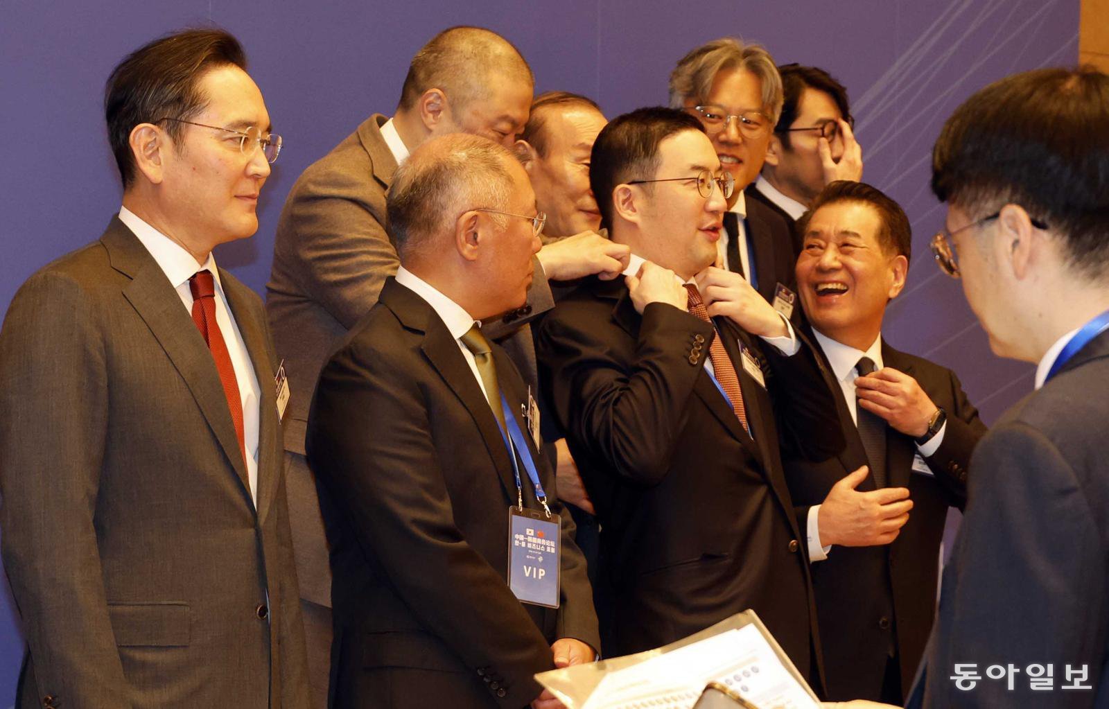 구자은 LS그룹 회장이 5일 중국 베이징 조어대에서 열린 한중 비즈니스포럼에서 구광모 LG그룹 회장의 옷매무새를 고쳐주고 있다. 송은석 기자 silverstone@donga.com