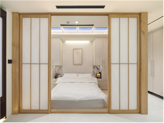 시니어 레지던스 내부의 침실 공간은 무자각 비접촉으로 환경 데이터를 측정할 수 있다. 한옥 감성의 목질에 실제 하늘을 구현한 듯한 조명 천창이 인상적이다. 사진제공=홈플릭스