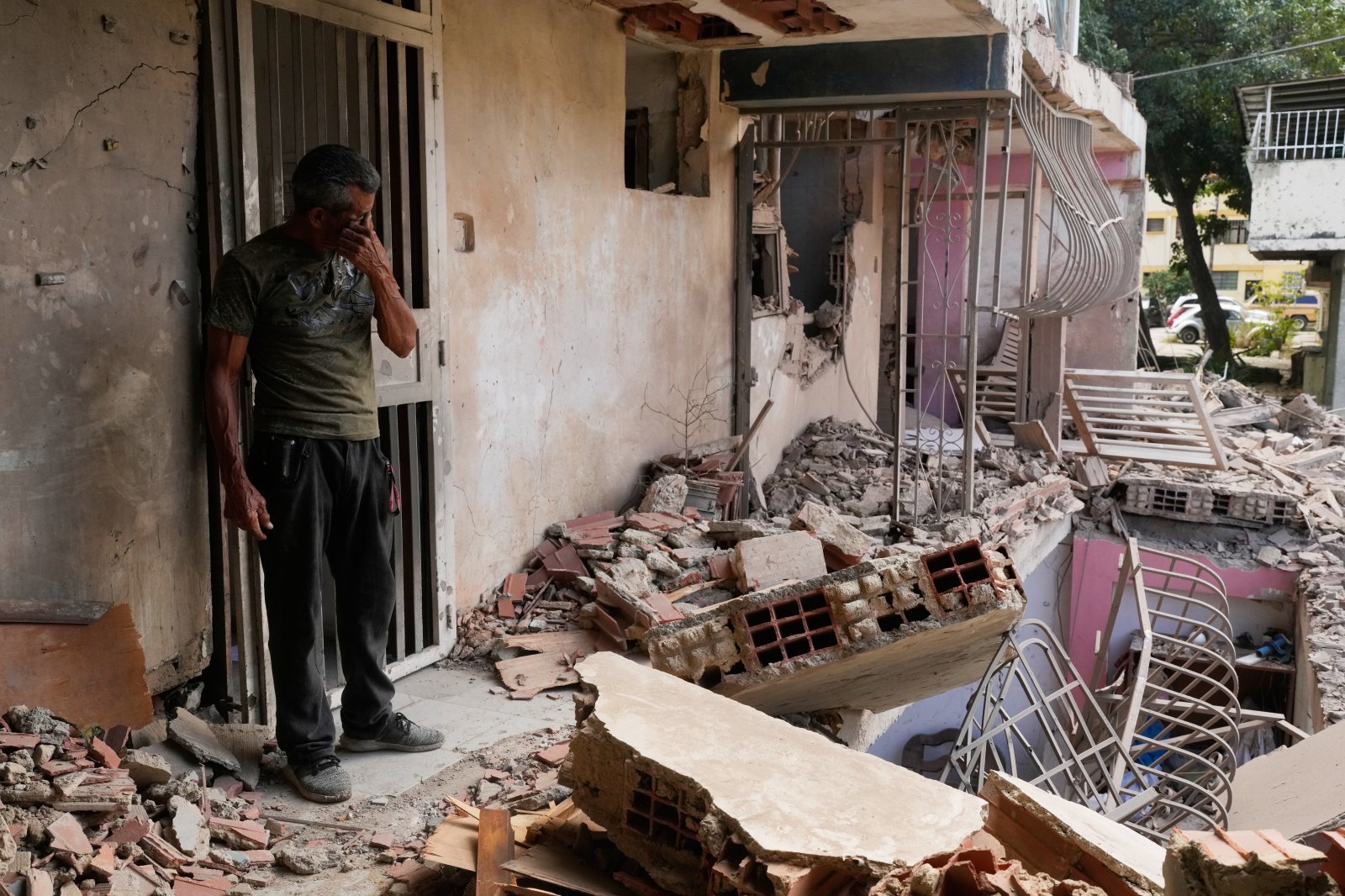 카라카스 인근 도시 카티아라마르의 건물이 미군 공습으로 처참히 파손됐다. 한 주민이 잔해 앞에서 괴로워하고 있다. 카라카스·카티아라마르=AP 뉴시스