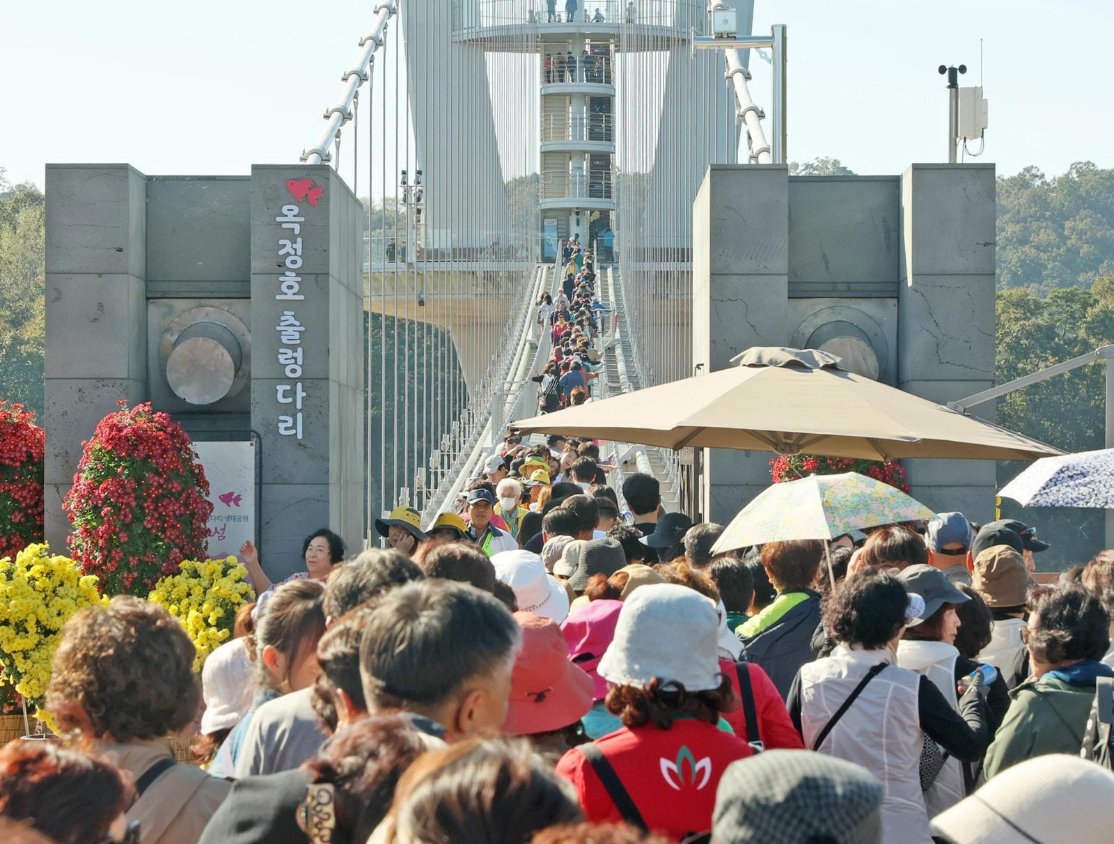 전북 임실군 옥정호 출렁다리를 찾은 관광객들이 붕어섬 생태공원으로 이어진 출렁다리를 오가고 있다. 임실군 제공