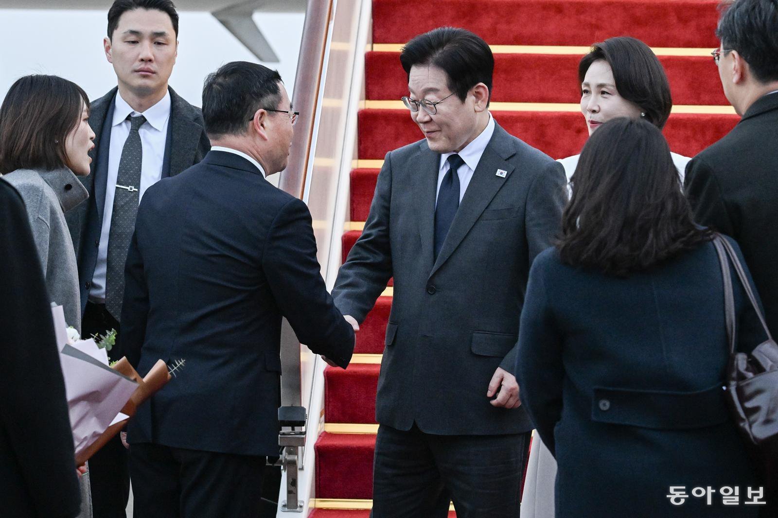 이재명 대통령과 부인 김혜경 여사가 6일 중국방문 두번째 도시인 상하이 푸동 국제공항 도착해 영접나온 천위젠 상하이시 부시장과 인사하고 있다. 20260106 청와대사진기자단 상하이=송은석 기자 silverstone@donga.com
