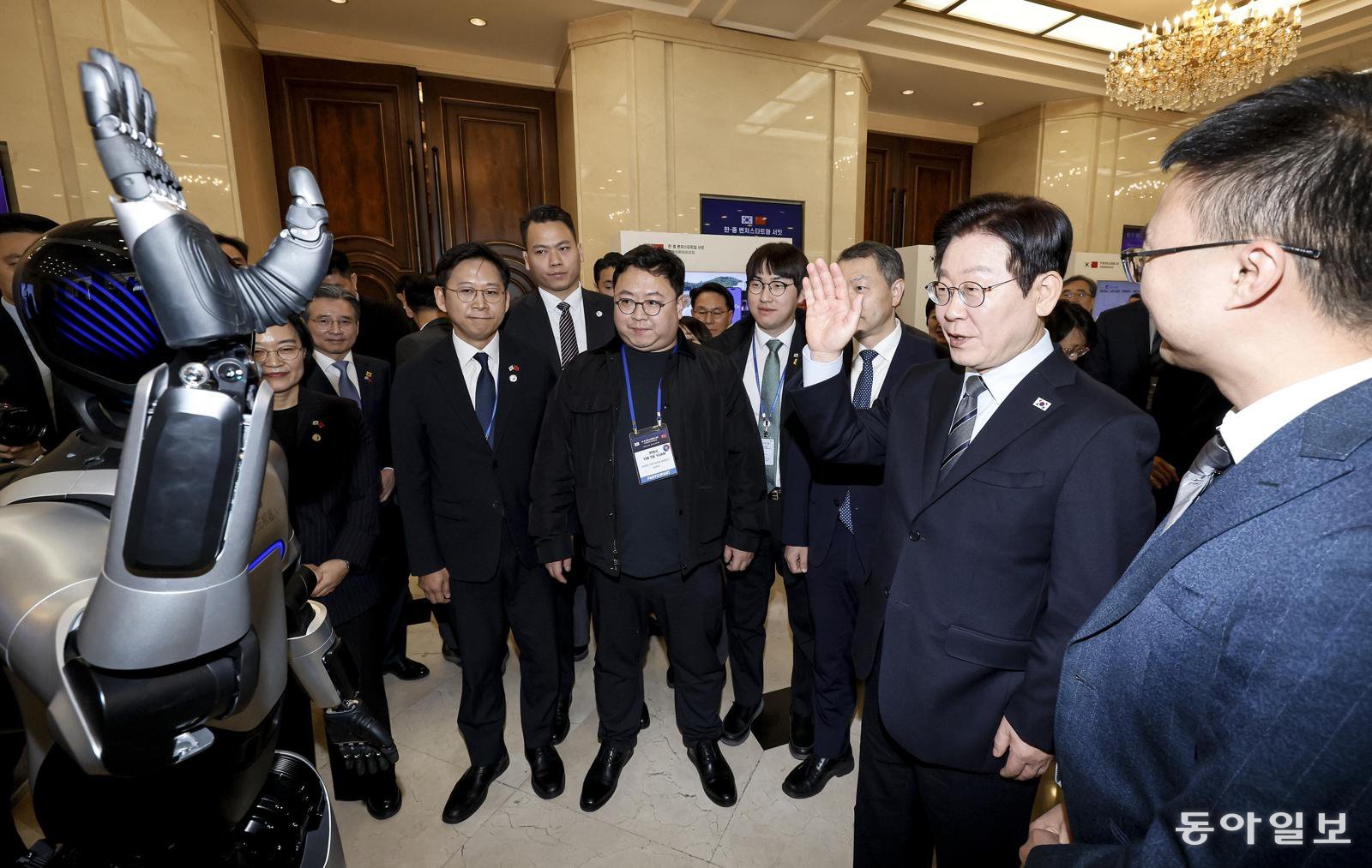 이재명 대통령이 7일 중국 상하이 국제회의중심에서 열린 한중 벤처 스타트업 서밋 행사에서 중국 기업 아지봇의 휴머노이드 로봇과 악수를 하고 있다.  상하이=송은석 기자 silverstone@donga.com