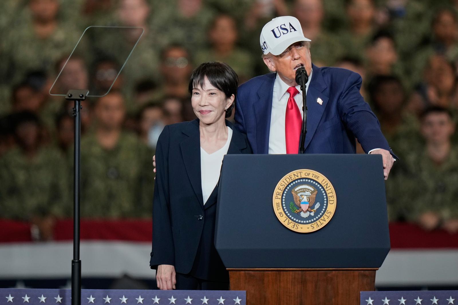 지난해 10월 28일 일본을 방문한 도널드 트럼프 미국 대통령이 주둔 미군 장병들에게 연설하며 다카이치 사나에 일본 총리(왼쪽)를 오른발로 안고 있다. 요코스카=AP 뉴시스