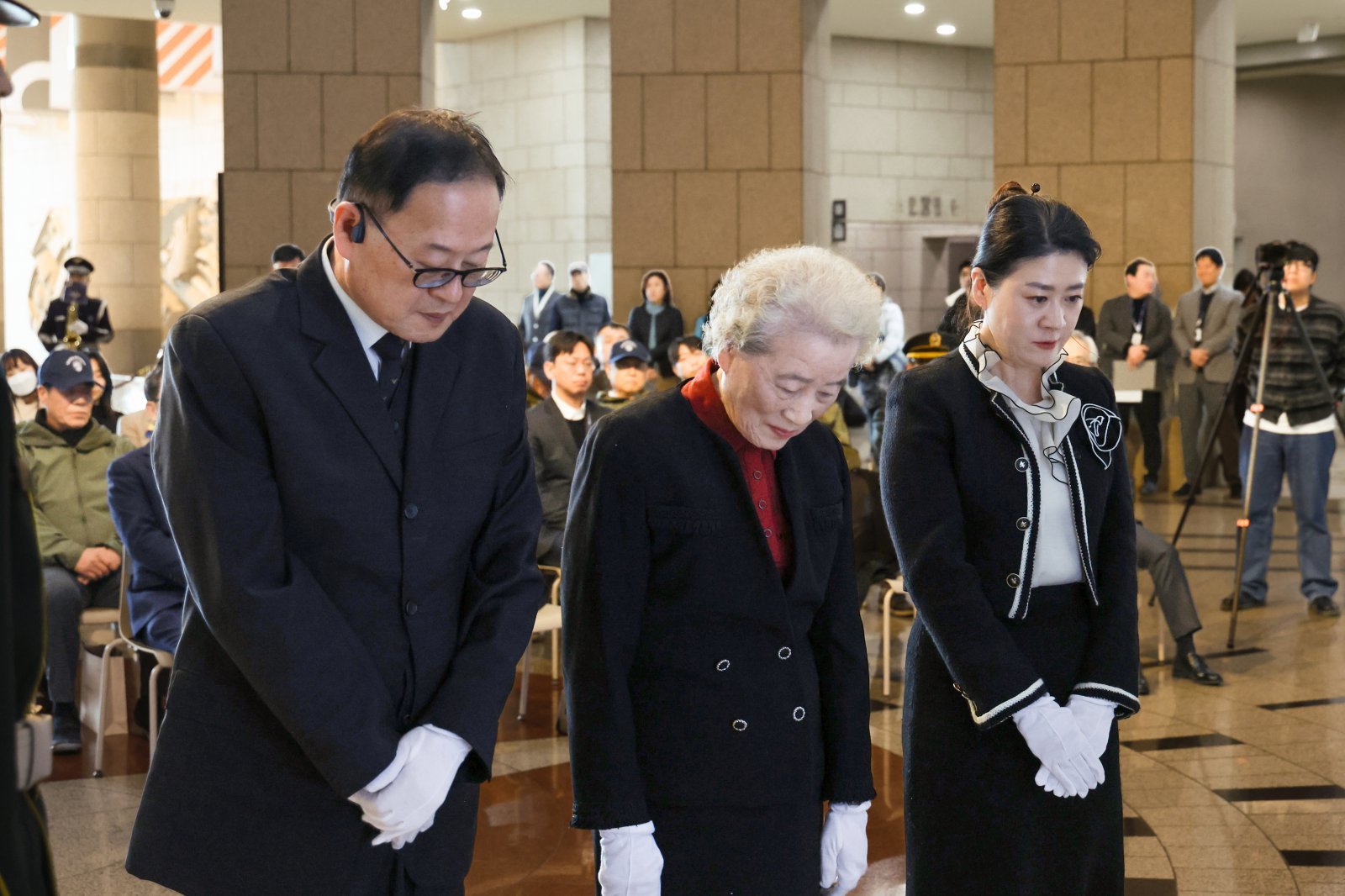8일 오후 전쟁기념관 중앙홀에서 열린 이재태 소장 현양행사에 참석한 유족들이 헌화 후 묵념하는 모습이다. (왼쪽부터 딸 이지은 씨, 아내 배광자 여사, 아들 이수호 씨)