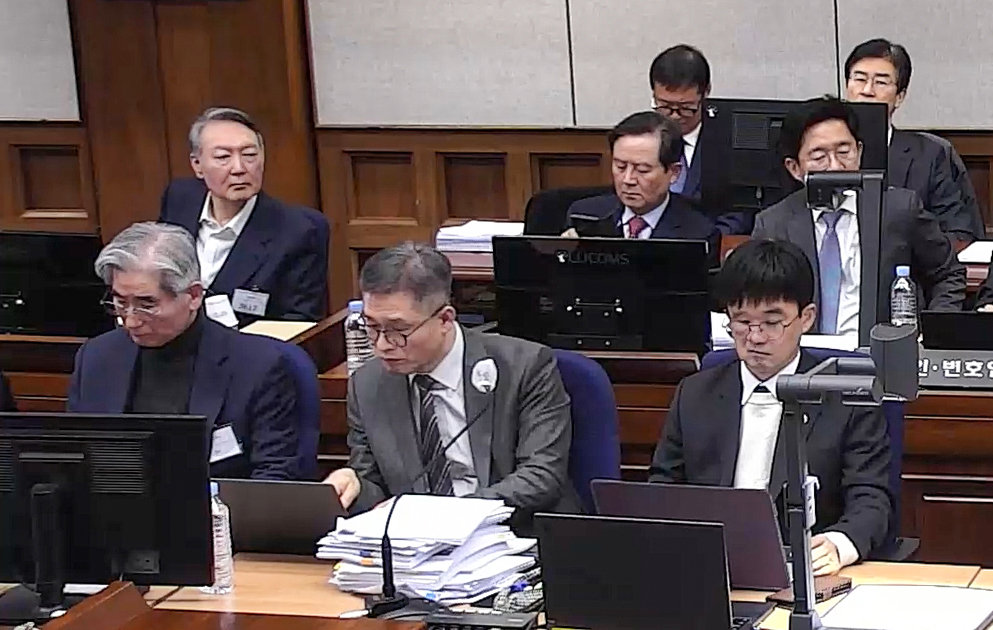 9일 오전 서울 서초구 서울중앙지법 417호 대법정에서 열린 내란 우두머리 혐의 결심 공판에 출석한 윤석열 전 대통령(왼쪽)이 재판 진행 내용을 듣고 있다. 서울중앙지법 재판 중계화면 캡처