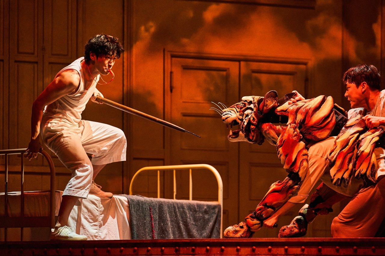 ‘라이프 오브 파이’에서 호랑이와 구명 보트에 남겨진 파이(박강현·왼쪽)는 호루라기를 불며 호랑이와 맞서며 길들인다. 호랑이 인형(퍼펫)을 조종하는 배우가 무대에 드러난다. 에스앤코 제공