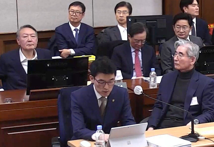 尹, 김용현과 동반 출석 9일 오전 서울 서초구 서울중앙지법 417호 대법정에서 열린 내란 우두머리 혐의 공판에 출석한 윤석열 전 대통령(둘째 줄 왼쪽)이 재판 진행 내용을 듣고 있다. 이날 김용현 전 국방부 장관(앞줄 왼쪽에서 두 번째)를 비롯해 노상원 전 국군정보사령관, 조지호 전 경찰청장 등 피고인 8명이 출석했다. 변호인 측에서 오후 9시가 넘도록 피고인 증거 조사를 이어가면서 결심 공판은 13일로 연기됐다. 서울중앙지법 재판 중계화면 캡쳐