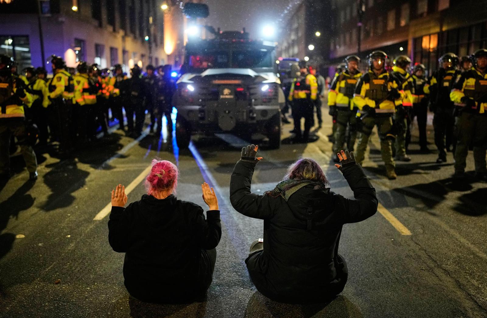 미국 미네소타주 미니애폴리스에서 열린 이민세관단속국(ICE) 항의 시위에 참석한 두 명의 시민이 무장경찰 차량을 가로막고 있다. 미니애폴리스=AP 뉴시스