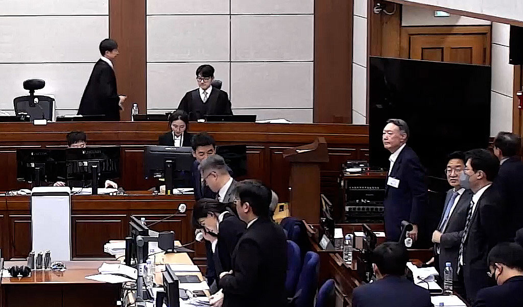 윤석열 전 대통령이 9일 오후 서울 서초구 서울중앙지방법원에서 열린 내란 우두머리 혐의 1심 결심 공판이 휴정되자 자리에서 일어서고 있다. 2026.1.9 서울중앙지방법원 제공 영상 캡쳐