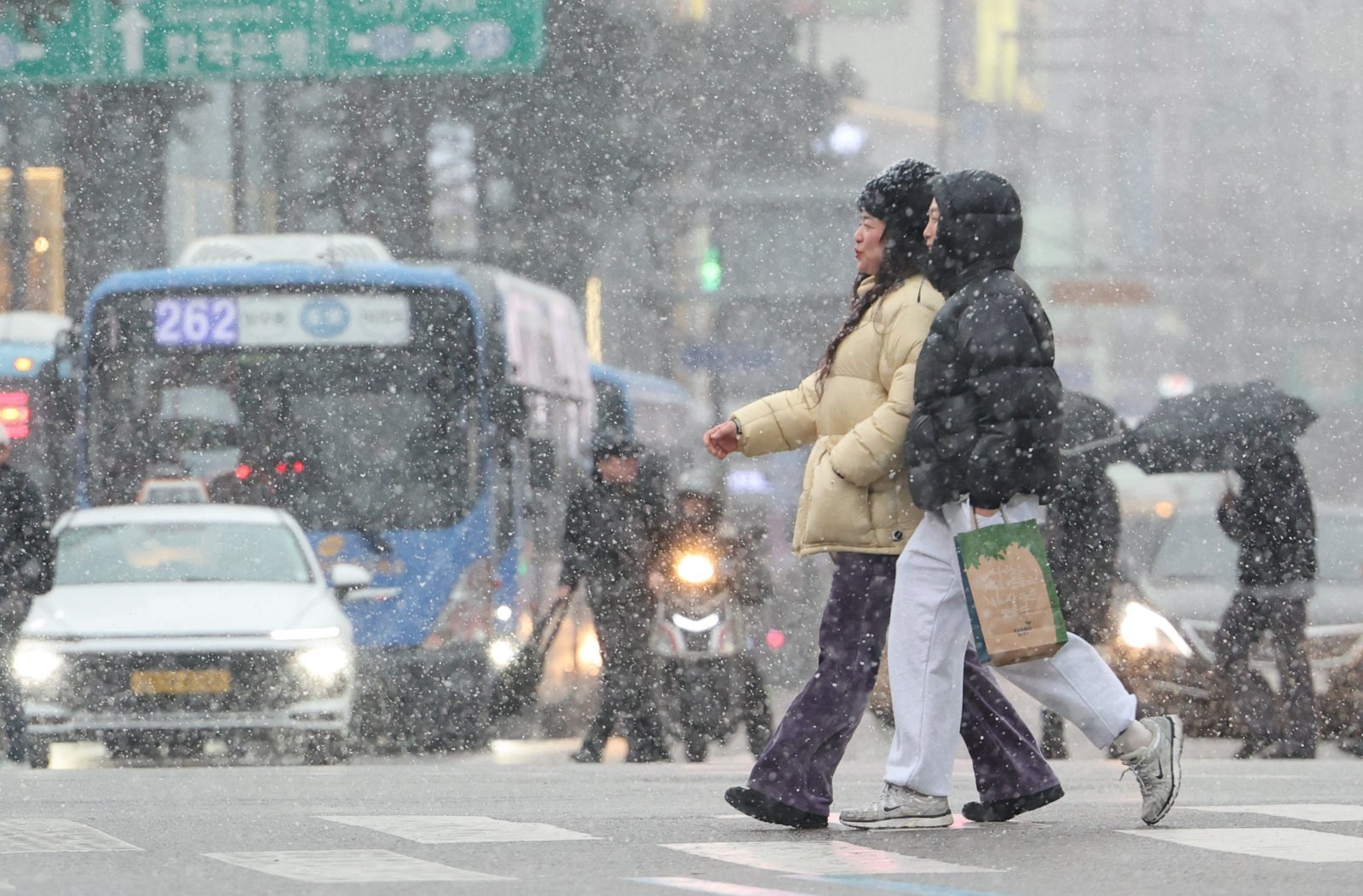 12일 오후 서울 중구 을지로에서 시민들이 눈을 맞으며 이동하고 있다. 뉴시스