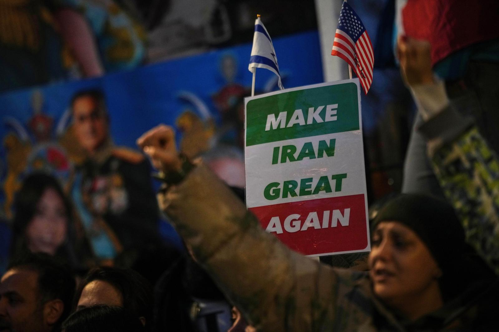 12일 영국 런던의 주영국 이란대사관 앞에서 시민들이 도널드 트럼프 미국 대통령의 정치 구호 “이란을 다시 위대하게”라고 적힌 팻말을 들고 이란의 반정부 시위대를 지지하고 있다. 같은 날 트럼프 대통령은 시위대를 유혈 진압하는 이란 당국에 대한 경고 의미로 “이란과 거래하는 모든 국가에 25%의 관세를 부과하겠다”고 밝혔다. 런던=AP 뉴시스