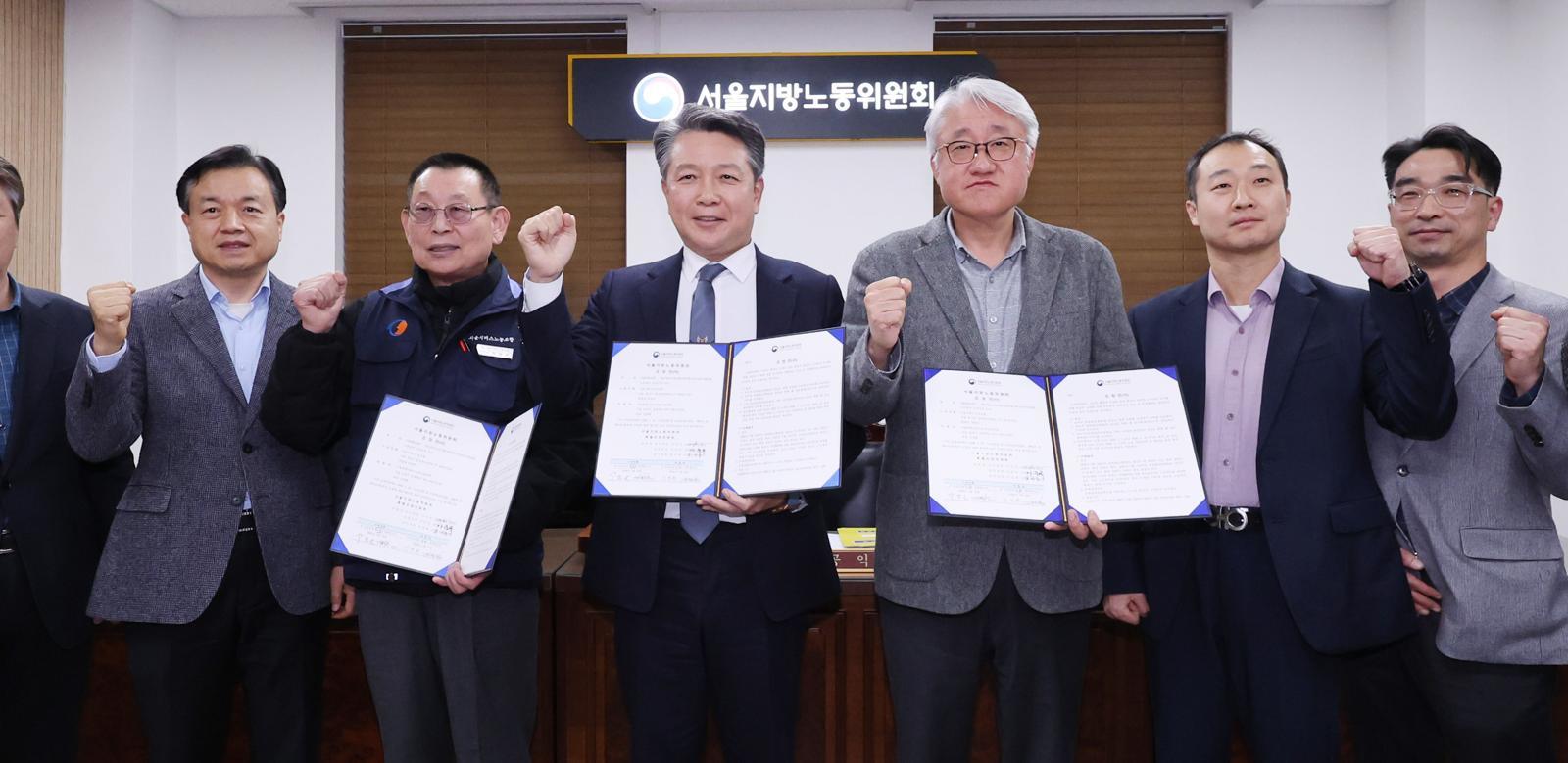 14일 서울 영등포구 서울지방노동위원회에서 열린 특별조정위원회 2차 사후 조정회의에서 서울 시내버스 노사가 임금협상에 극적으로 합의한 뒤 박점곤 서울시버스노동조합 위원장과 김정환 서울시버스사업조합 이사장을 비롯한 참석자들이 기념 촬영을 하고 있다. 2026.1.15/뉴스1