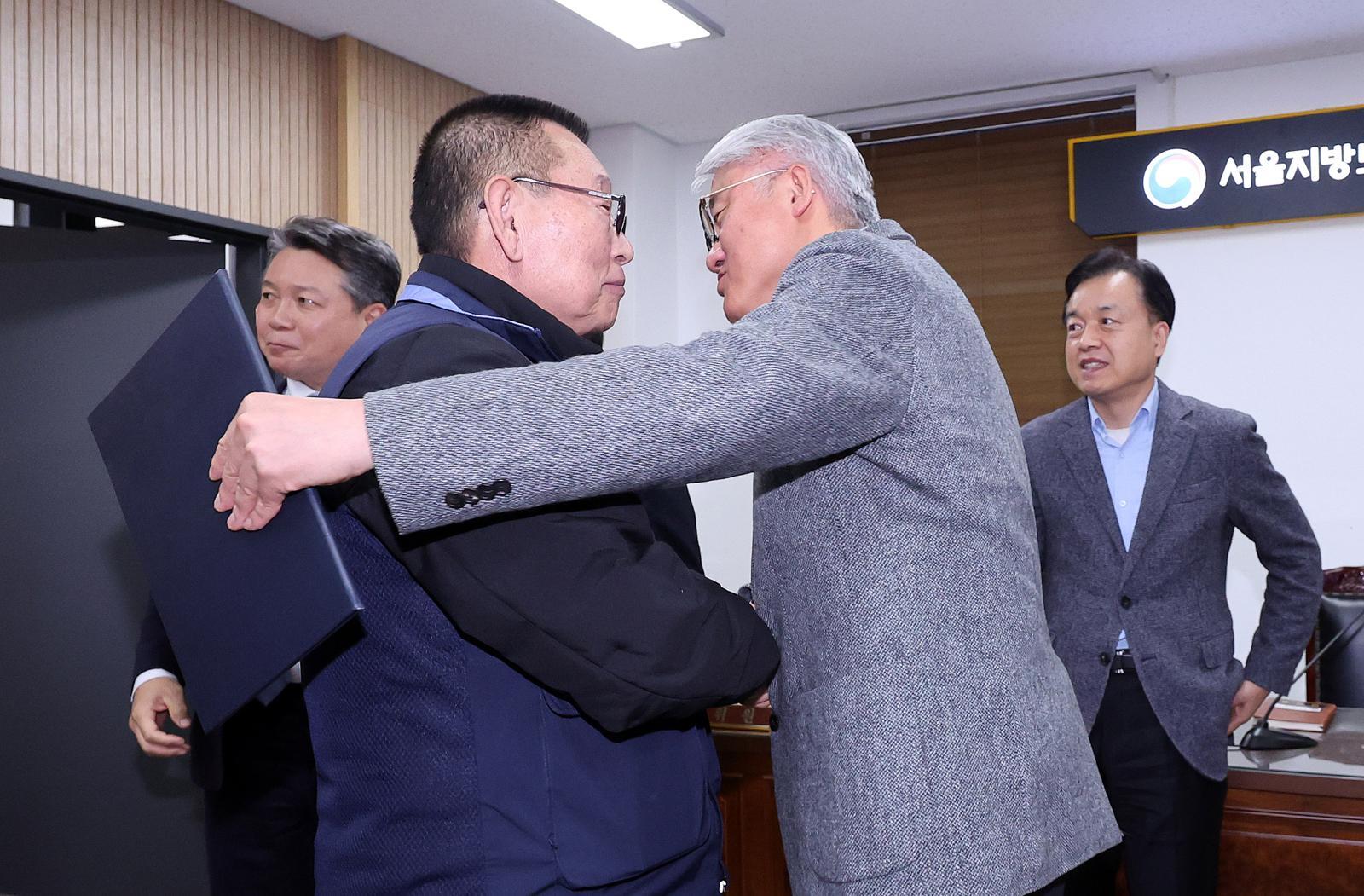 14일 서울 영등포구 서울지방노동위원회에서 열린 특별조정위원회 2차 사후 조정회의에서 서울 시내버스 노사가 임금협상에 극적으로 합의한 뒤 박점곤 서울시버스노동조합 위원장과 김정환 서울시버스사업조합 이사장이 포옹을 하고 있다. 2026.1.15/뉴스1