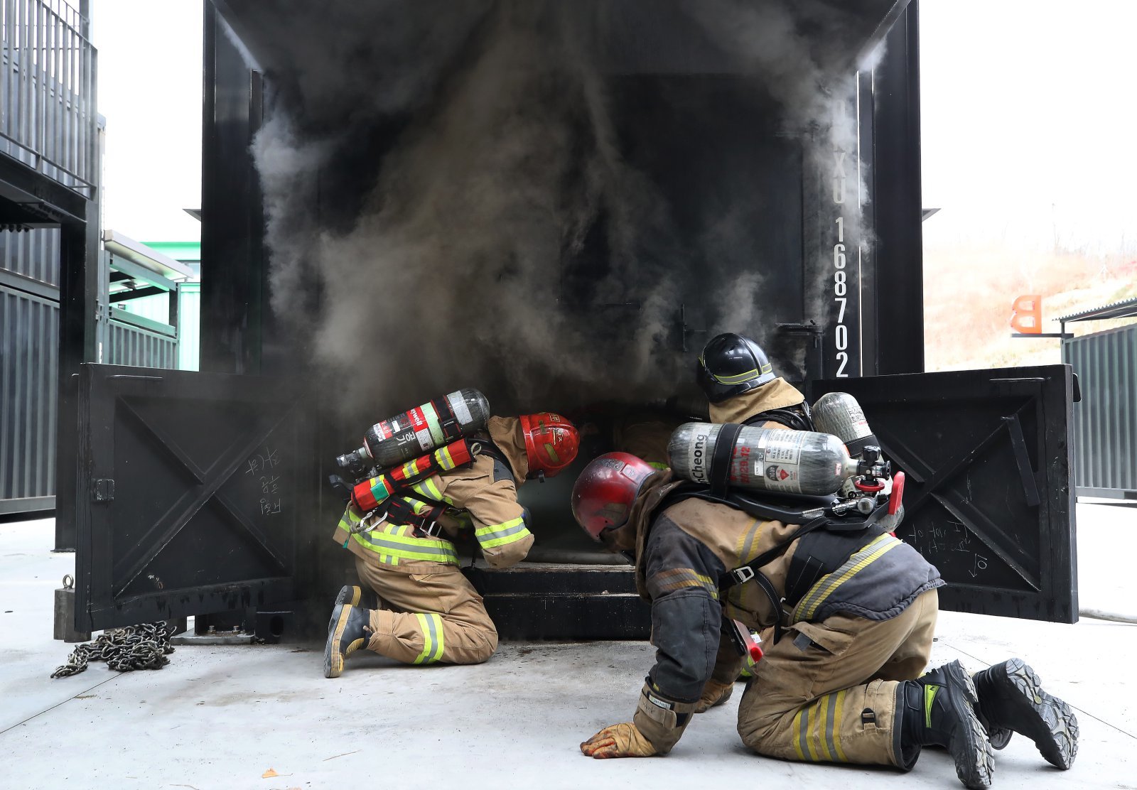 지난달 16일 오후 대구 동구 대구소방교육안전센터에서 열린 ‘실화재 종합훈련 역량강화 특별교육’에 참여한 소방관들이 컨테이너 모형주택 내부에서 불과 연기가 번지는 과정과 창 또는 문 개방에 따른 내부 상황 변화를 지켜보고 있다.  2025.12.16/뉴스1