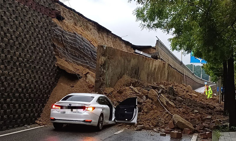 지난해 7월 16일 경기 오산시 가장교차로 고가도로 옹벽이 무너져 차량이 깔려 있다. 40대 운전자는 숨졌다. 해당 옹벽은 사고 전 정밀안전 점검에서 양호 판정을 받았으나, 조사 결과 보고서에 예전 사진을 재사용하는 등 부실 점검 정황이 드러났다. 경기소방재난본부 제공