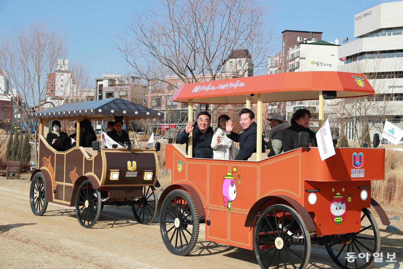 김두겸 울산시장과 시민들이 14일 태화강 국가정원에서 열린 ‘울산 마차’ 시승회에 참석해 손을 흔들고 있다. 말 대신 전기로 움직이는 이 마차는 태화강 국가정원과 울산대공원에서 관광 콘텐츠로 운영될 예정이다. 울산시 제공