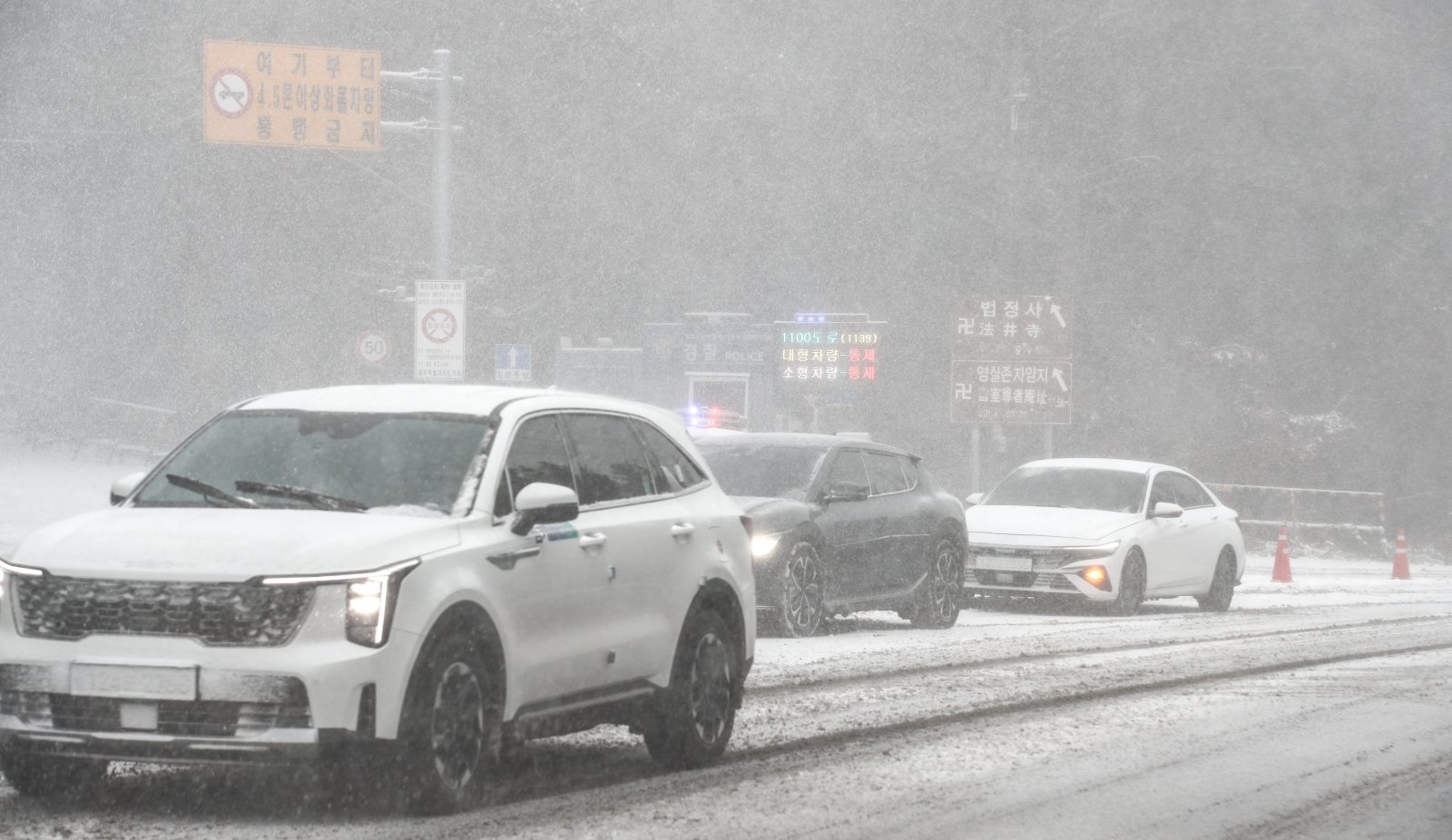 제주 산지·중산간·동부·남부에 대설특보가 내려진 11일 오전 제주시 어승생 삼거리 입구에서 제주서부경찰서 소속 경찰관이 도로통제를 하고 있다.   기상청에 따르면 제주도는 12일까지 한라산 등 고지대를 중심으로 최대 15㎝의 눈이 내려 쌓일 것으로 예측됐다. 2026.01.11 제주=뉴시스