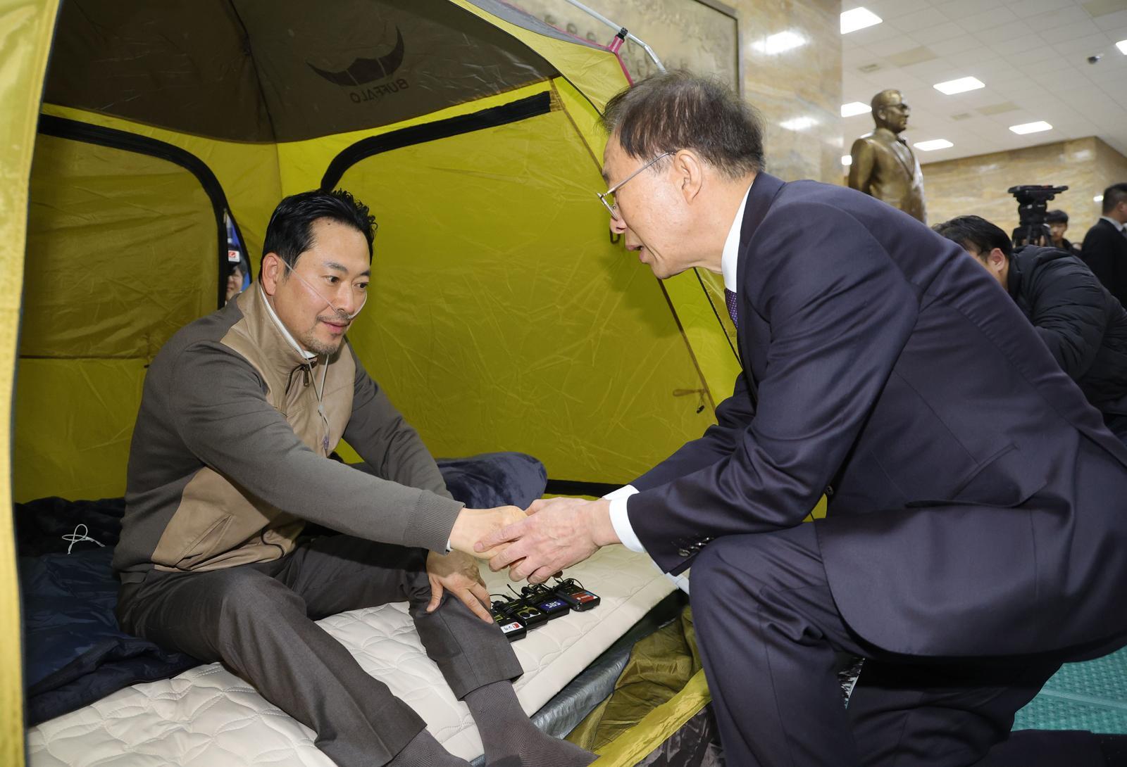 단식 중인 장동혁 국민의힘 대표가 21일 서울 여의도 국회 로텐더홀 단식 농성장을 찾은 이석연 국민통합위원장과 인사하고 있다. (공동취재) ⓒ News1