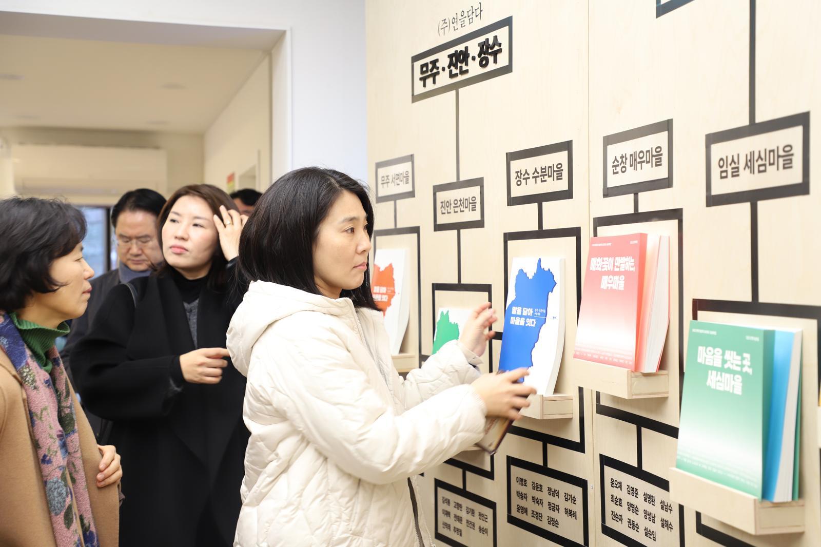 전북도지사 관사를 리모델링해 복합문화공간으로 재탄생한 전주 한옥마을 내 하얀 양옥집에서 지난해 12월 열린 ‘움직이는 기억, 살아 있는 마을’ 전시회를 찾은 관람객들이 전북 10개 시·군, 10개 마을 주민의 기억을 엮어 만든 문학집을 살펴보고 있다. 전북문화관광재단 제공