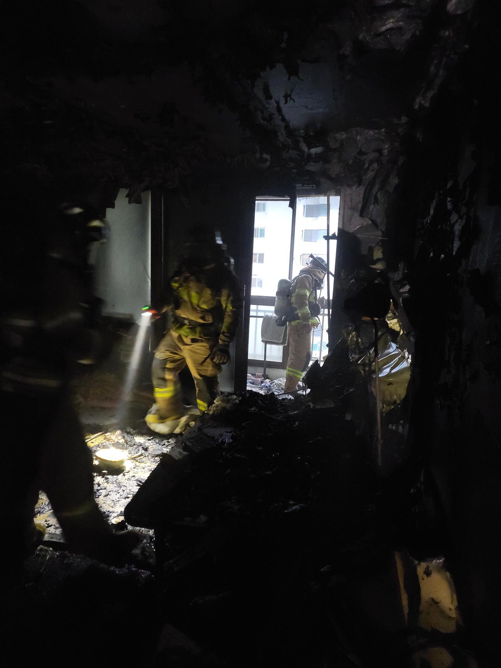 전남 광양소방서 소방관들이 19일 오후 아파트 5층 화재 현장을 살펴보고 있다. 전남소방본부 제공.