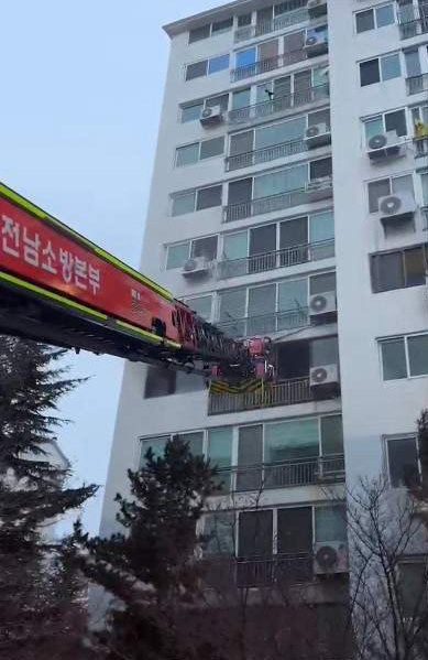 전남 광양소방서 소방관들이 19일 오후 52m길이 사다리 차량을 이용해 불이 난 아파트에서 구조 활동을 벌이고 있다. 광양소방서 제공.