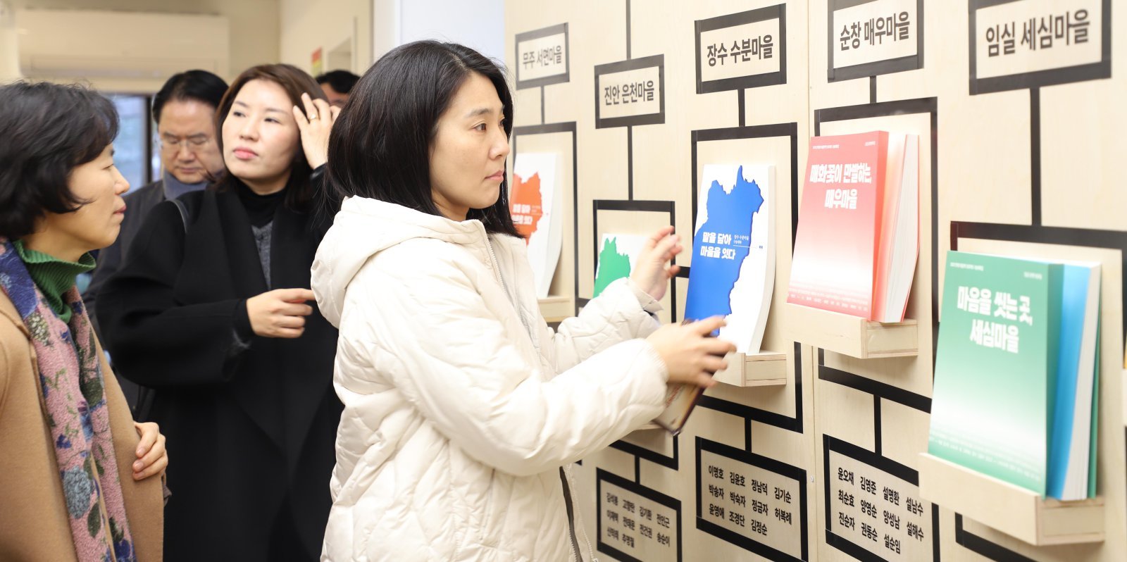 전북도지사 관사를 리모델링해 복합문화공간으로 재탄생한 전주 한옥마을 내 하얀 양옥집에서 지난해 12월 열린 ‘움직이는 기억, 살아 있는 마을’ 전시회를 찾은 관람객들이 전북 10개 시군, 10개 마을 주민의 기억을 엮어 만든 문학집을 살펴보고 있다. 전북문화관광재단 제공
