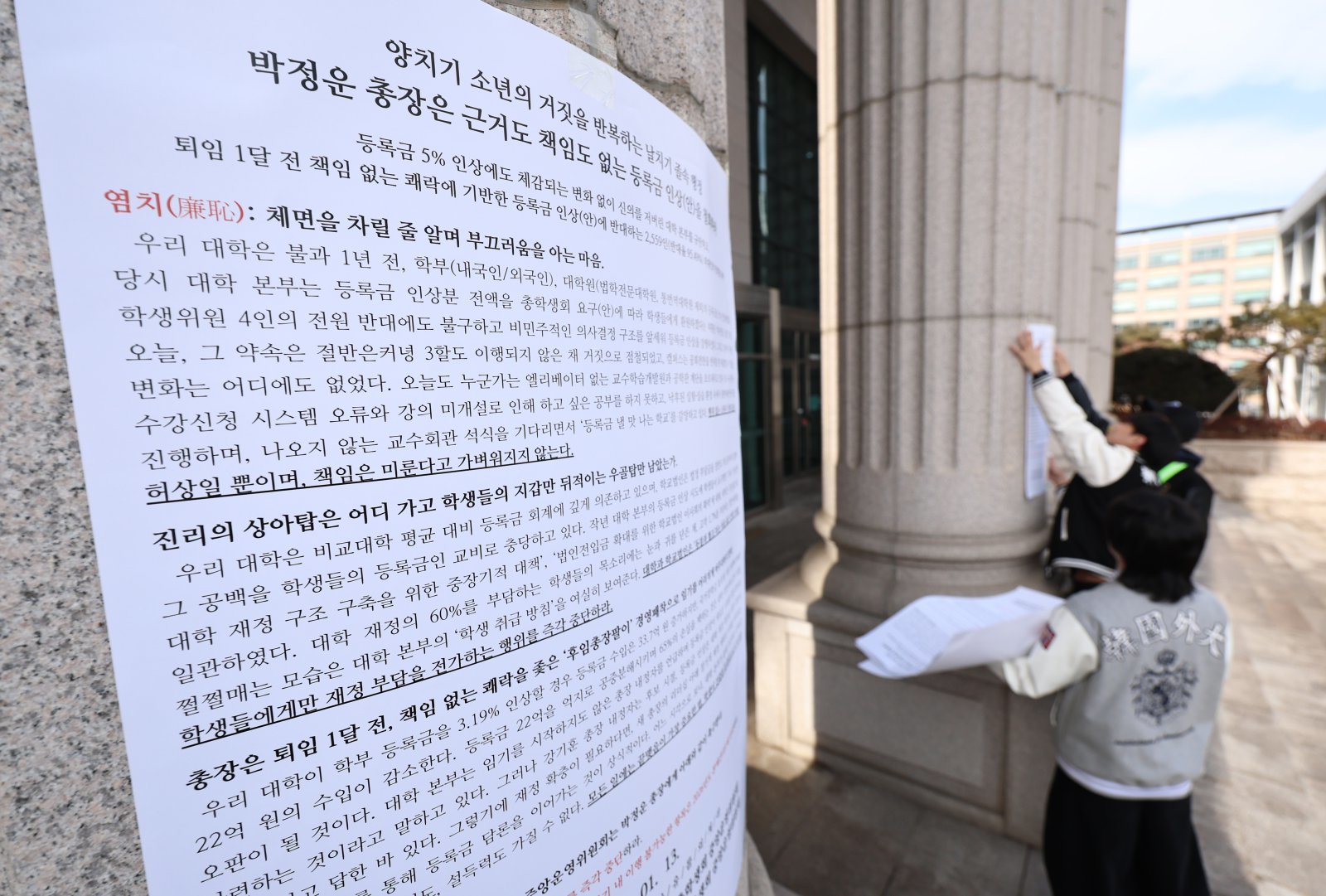 한국외국어대학교 총학생회를 비롯한 학생들이 19일 오후 서울 동대문구 한국외대에서 학교 측이 제시한 올해 3.19%의 등록금 인상안에 항의하는 내용의 대자보를 붙이고 있다. 2026.1.19/뉴스1