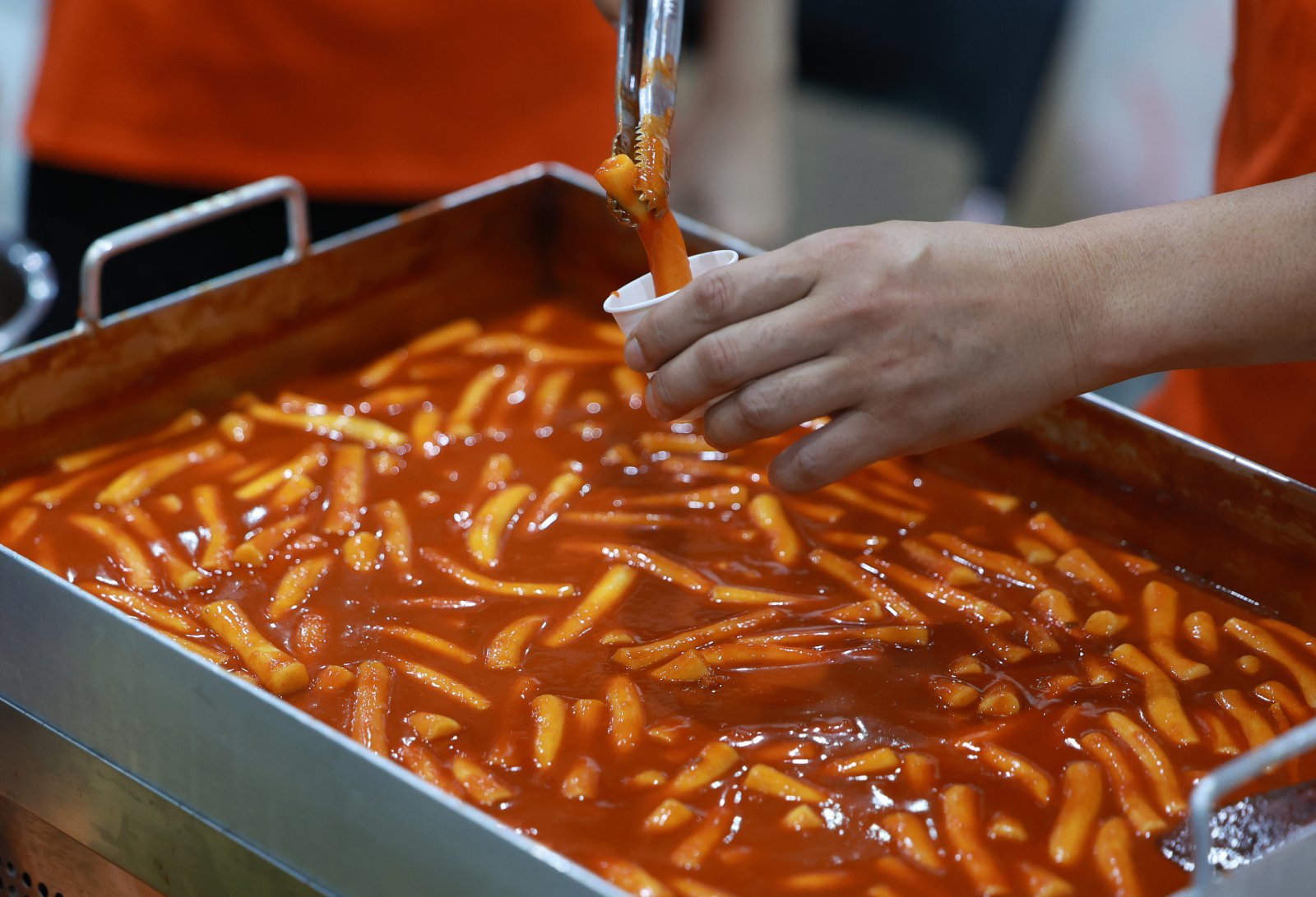 31일 서울 강서구 코엑스 마곡에서 열린 K-푸드페스타에서 한 관계자가 시식용 떡볶이를 담고 있다. 2025.08.31. 서울=뉴시스