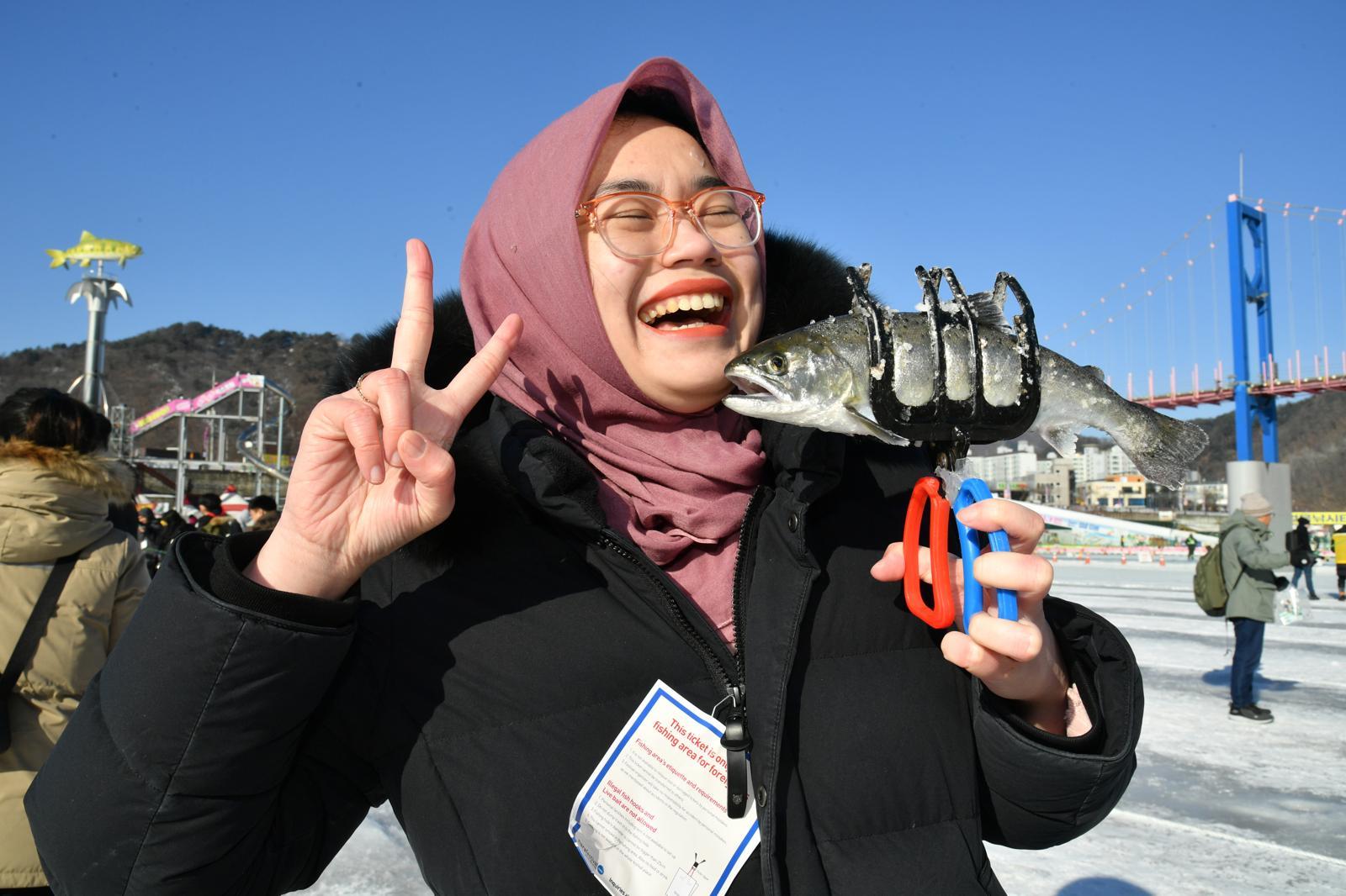 24일 강원 화천 산천어축제에서 산천어를 잡은 외국인 관광객이 환하게 웃고 있다. 화천군 제공