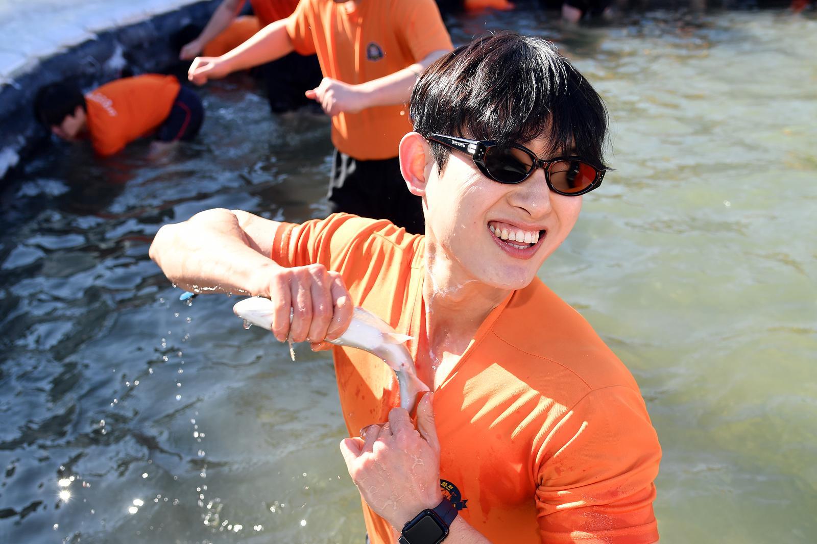24일 강원 화천 산천어축제에서 산천어 맨손잡기에 나선 관광객이 즐거워하고 있다. 화천군 제공