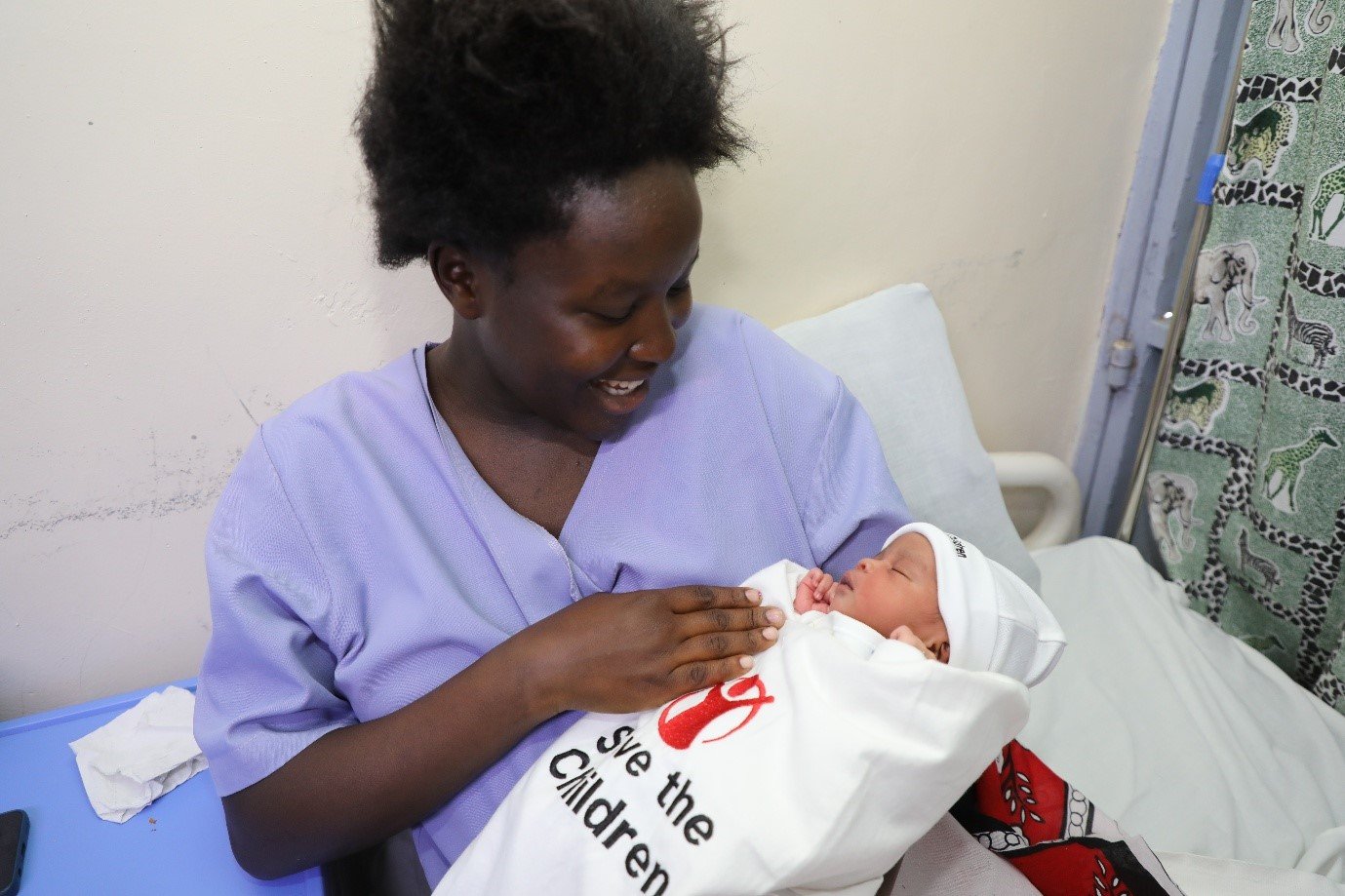 케냐 보건 인력이 신생아를 안고 있다.
