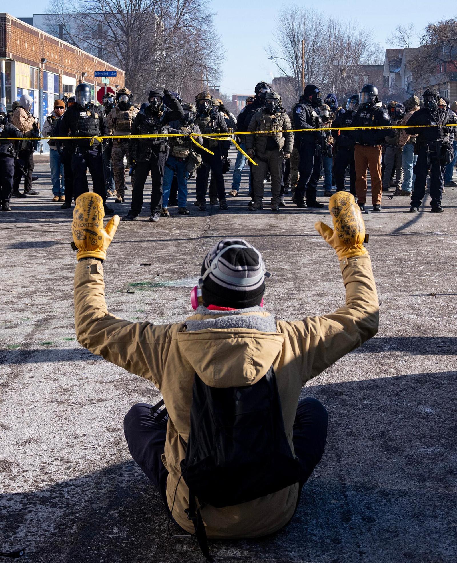 美정부 반이민정책에 항의하는 시민
24일(현지 시간) 미국 미네소타주 미니애폴리스에서 한 시민이 거리에 앉아 두 손을 든 채 연방 요원들과 대치하고 있다. 미니애폴리스=AP 뉴시스