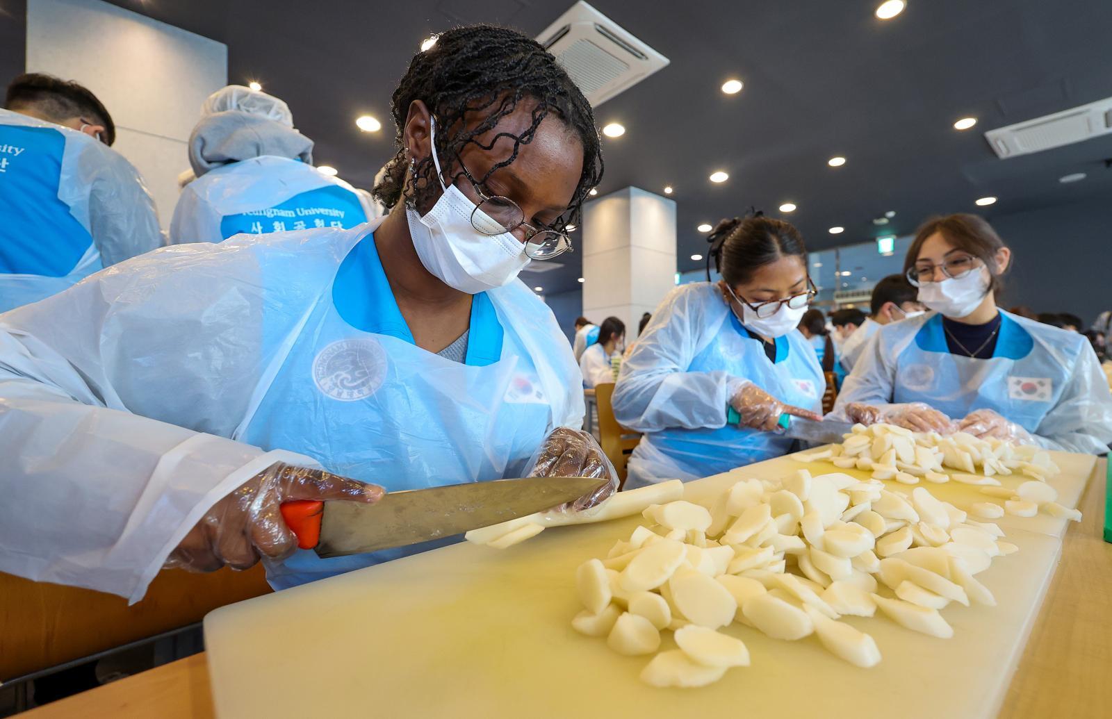 5일 경북 경산시 영남대학교 학생회관 식당에서 열린 ‘제5회 사랑의 떡국 나눔 행사’에서 외국인 유학생들이 떡국에 쓰일 가래떡을 썰고 있다. 경산=뉴시스