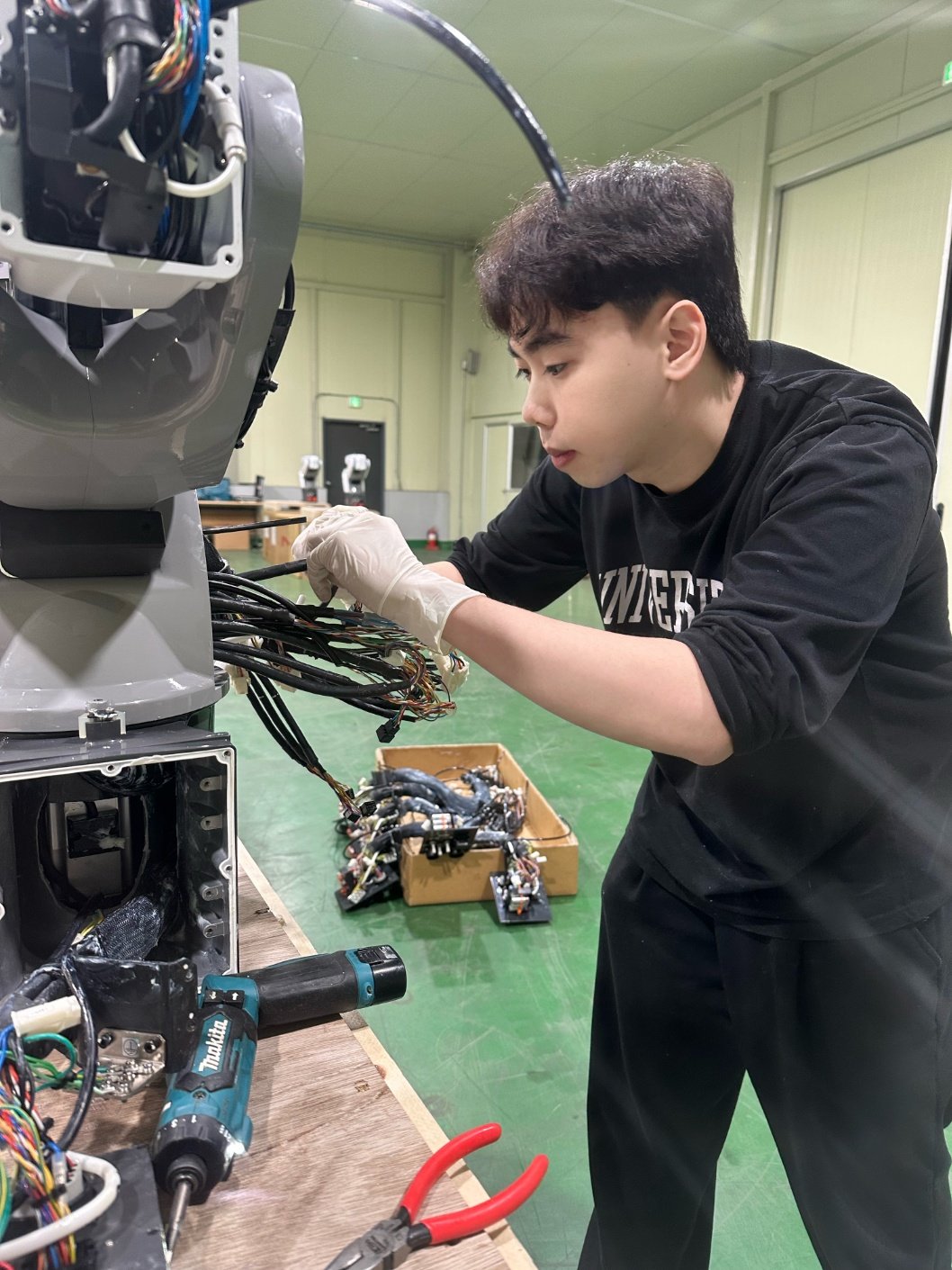 이달 7일 한국폴리텍다솜고 컴퓨터기계과를 졸업하고 산업용 로봇 제작 기업에 입사한 베트남 출신 동응옥두안 씨가 로봇 내부 연결선을 살피고 있다. 충북 제천에 있는 한국폴리텍다솜고는 다문화 청소년을 위한 기술계 기숙형 대안학교다. 2012년 개교했으며 매년 45명 안팎의 현장형 기능인재를 양성하고 있다.한국폴리텍대 제공