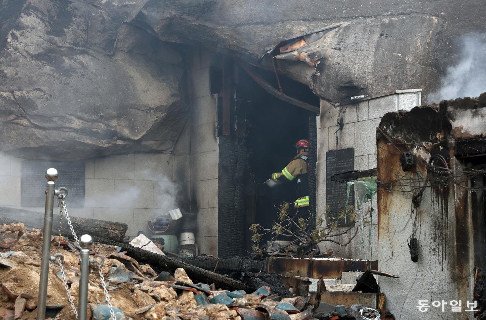 26일 서울 노원구 수락산에서 산불이 발생했다. 이날 화재로 수암사 대웅전이 소실됐다.  소방대원이 석굴법당에 물을 뿌리고 있다. 김재명 기자 base@donga.com