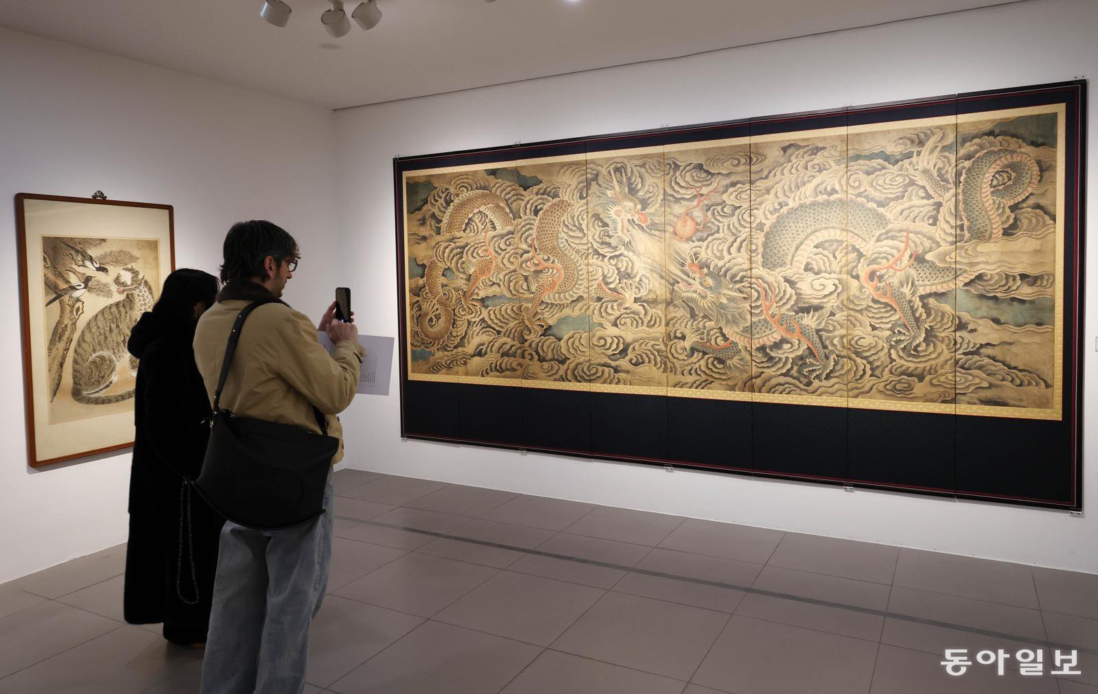 20일 서울 종로구 삼청동 갤러리현대에서 민중의 삶과 해학을 담은 민화와 권위와 형식의 미학이 돋보이는 궁중 회화를 함께 선보이는 기획전을 관람객들이 감상하고 있다. 전영한 기자 scoopjyh@donga.com