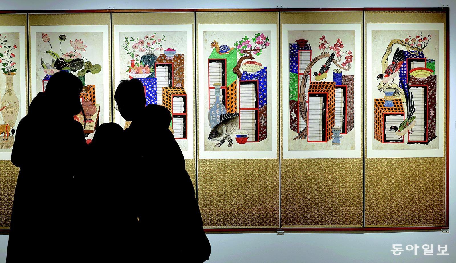 20일 서울 종로구 삼청동 갤러리현대에서 민중의 삶과 해학을 담은 민화와 권위와 형식의 미학이 돋보이는 궁중 회화를 함께 선보이는 기획전을 관람객들이 감상하고 있다. 전영한 기자 scoopjyh@donga.com