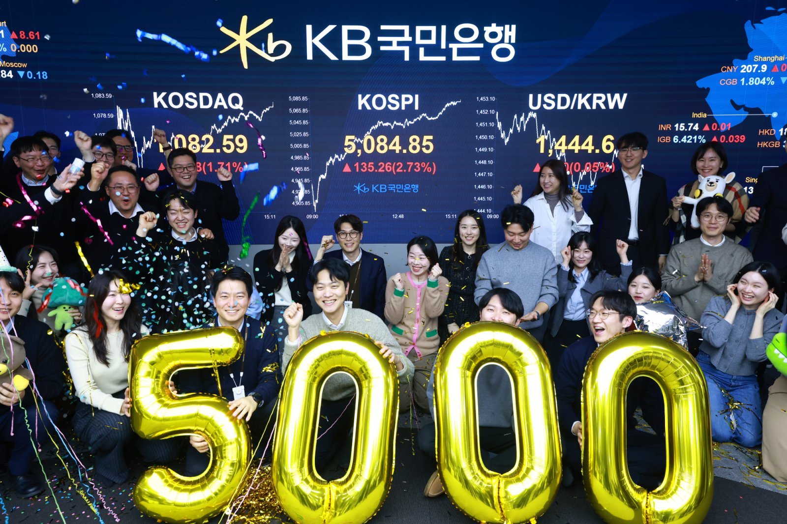 코스피가 종가 기준 사상 처음 5000선을 돌파한 27일 오후 서울 영등포구 KB국민은행 딜링룸에서 직원들이 축하 세리머니를 하고 있다. 이날 코스피지수는 전일대비 135.26p(2.73%) 오른 5084.85로 장을 마감했다. 국민은행 제공