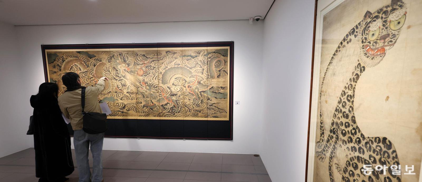 20일 서울 종로구 갤러리현대 본관에서 열리고 있는 ‘장엄과 창의: 한국 민화의 변주’전을 찾은 관람객들이 ‘쌍룡희주도’를 감상하고 있다. 전영한 기자 scoopjyh@donga.com
