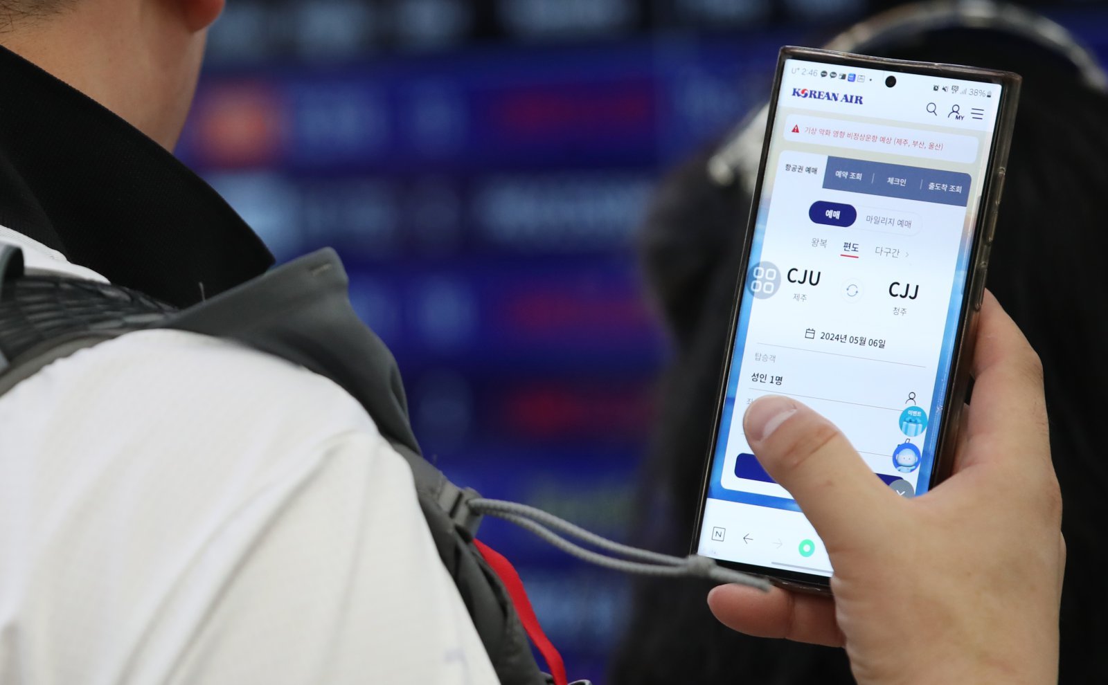 공항 출발장에서 한 승객이 휴대전화로 항공권을 검색하고 있는 모습. /뉴스1DB