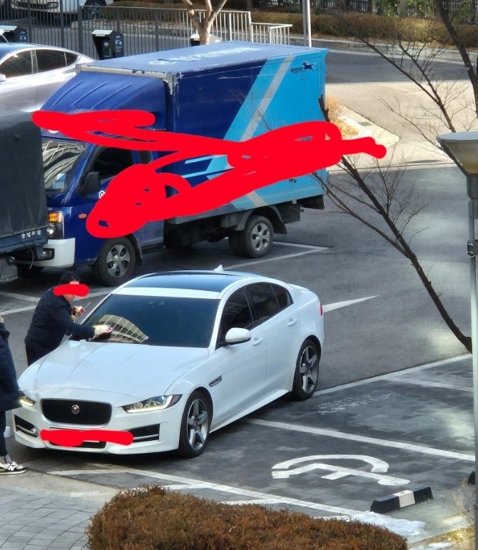 목장갑을 끼고 불법주차 스티커를 제거하고 있는 경비원. 온라인커뮤니티 보배드림 캡처