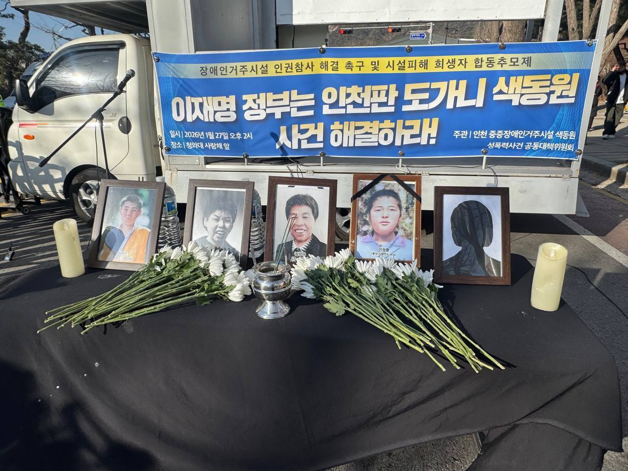 27일 청와대 사랑채 앞에서 장애인 거주시설 희생자 합동추모제가 열렸다. 희생자들의 영정 사진 앞에 추모를 의미하는 국화꽃이 보인다. 전국장애인차별철폐연대 제공