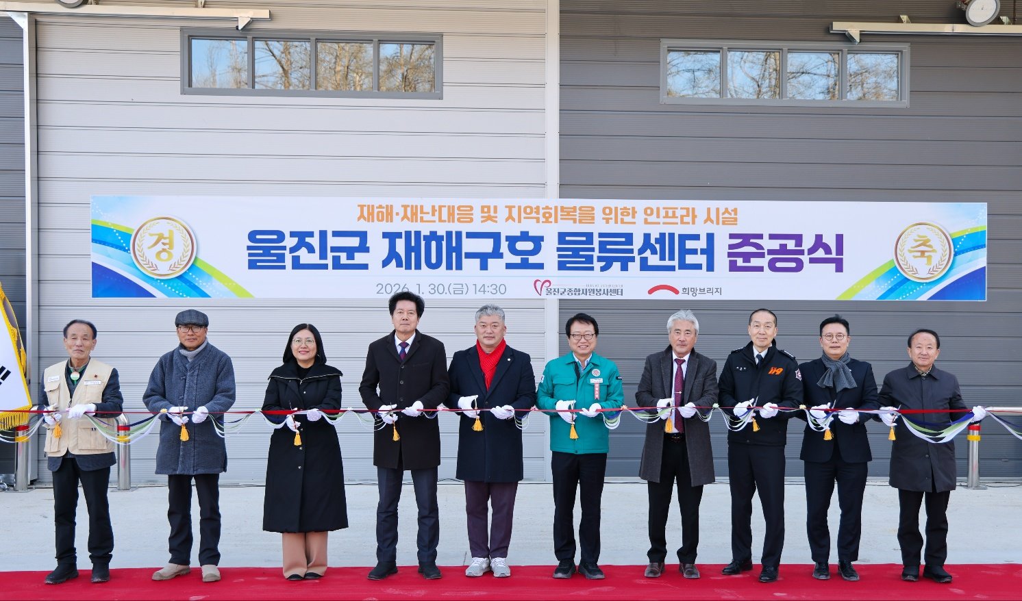 지난달 30일 경북 울진군에서 열린 재해구호물류센터 준공식에서 희망브리지와 울진군 관계자들이 기념 테이프를 자르고 있다. 희망브리지 제공